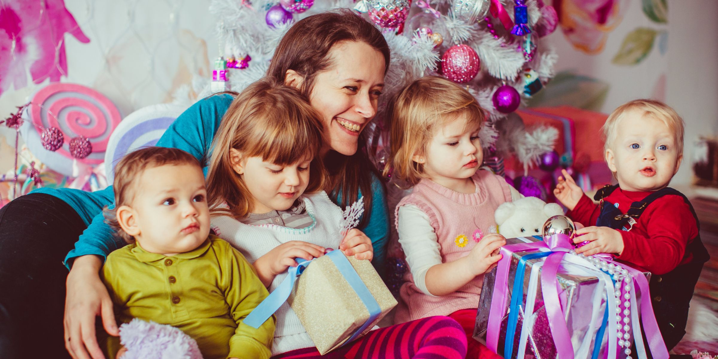 A happy mother sitting surrounded by her young children | Source: Magnific