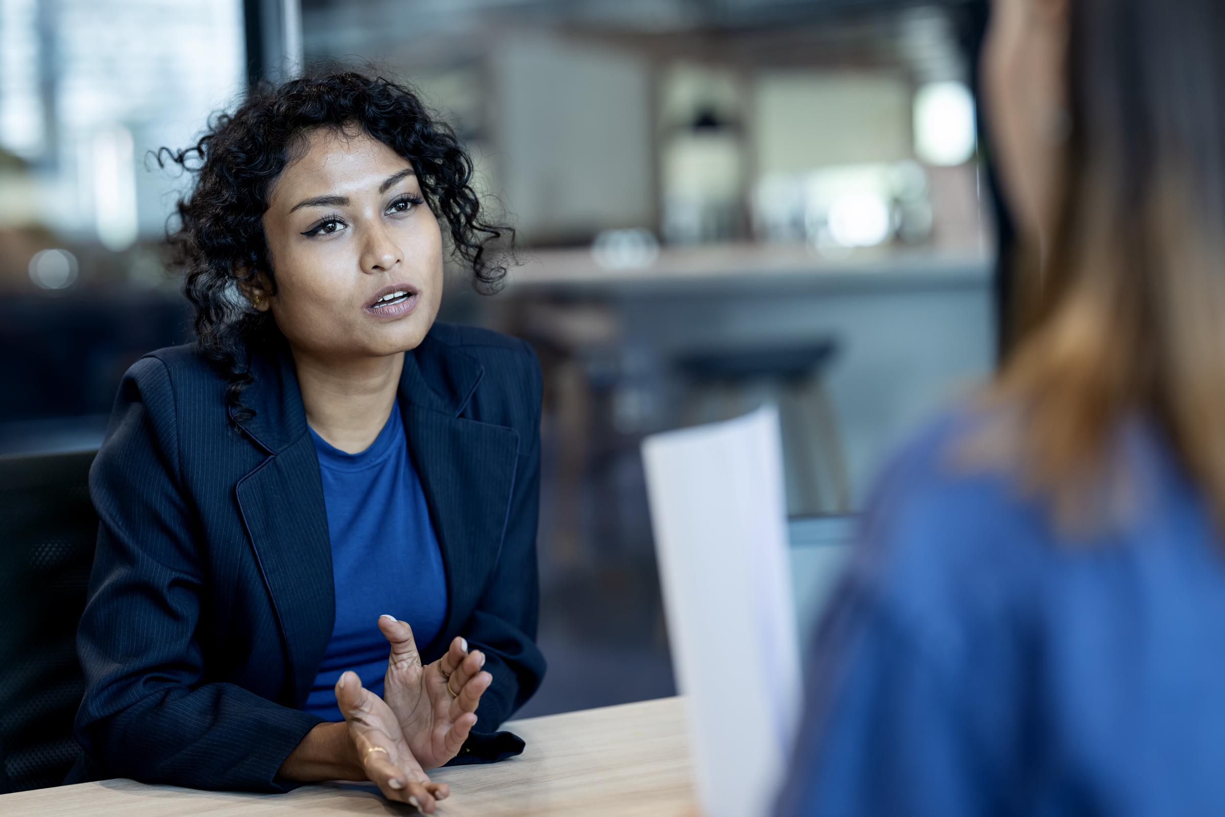 A woman asking questions during a meeting with her supervisor | Source: Getty Images