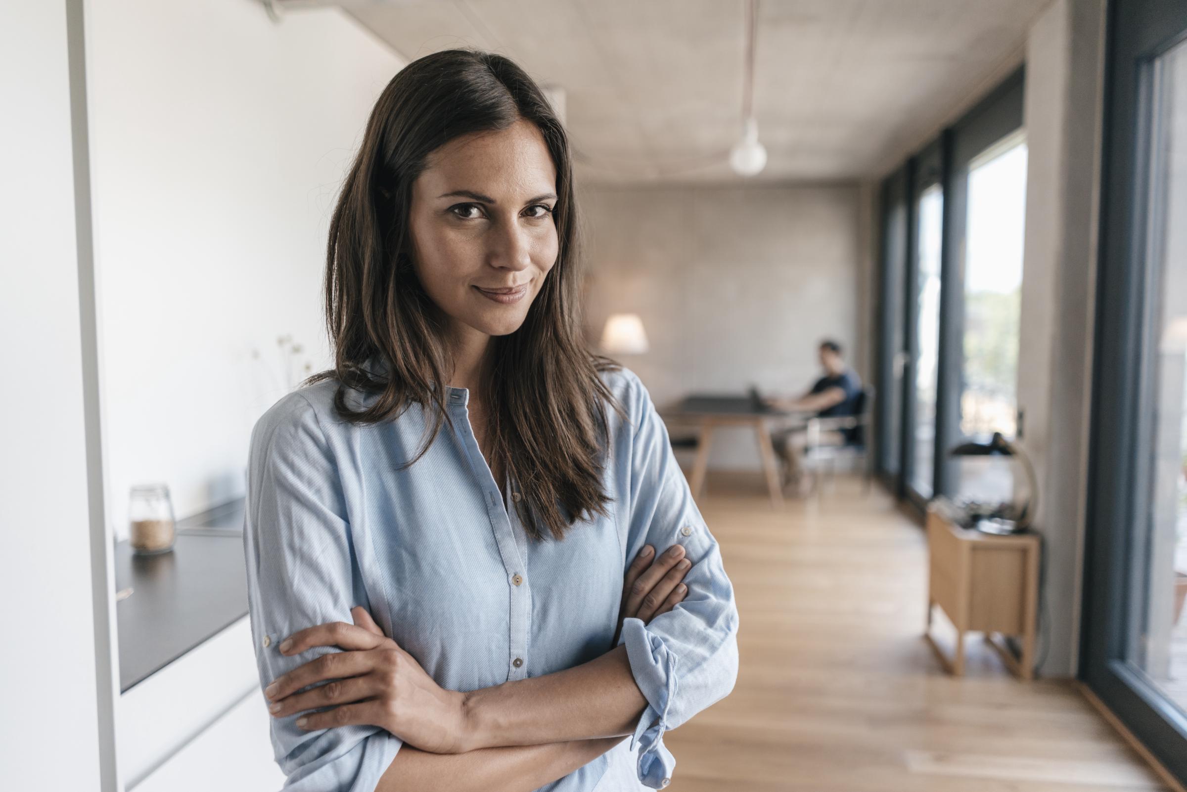 Woman smiling at home with a man in the background | Source: Getty Images