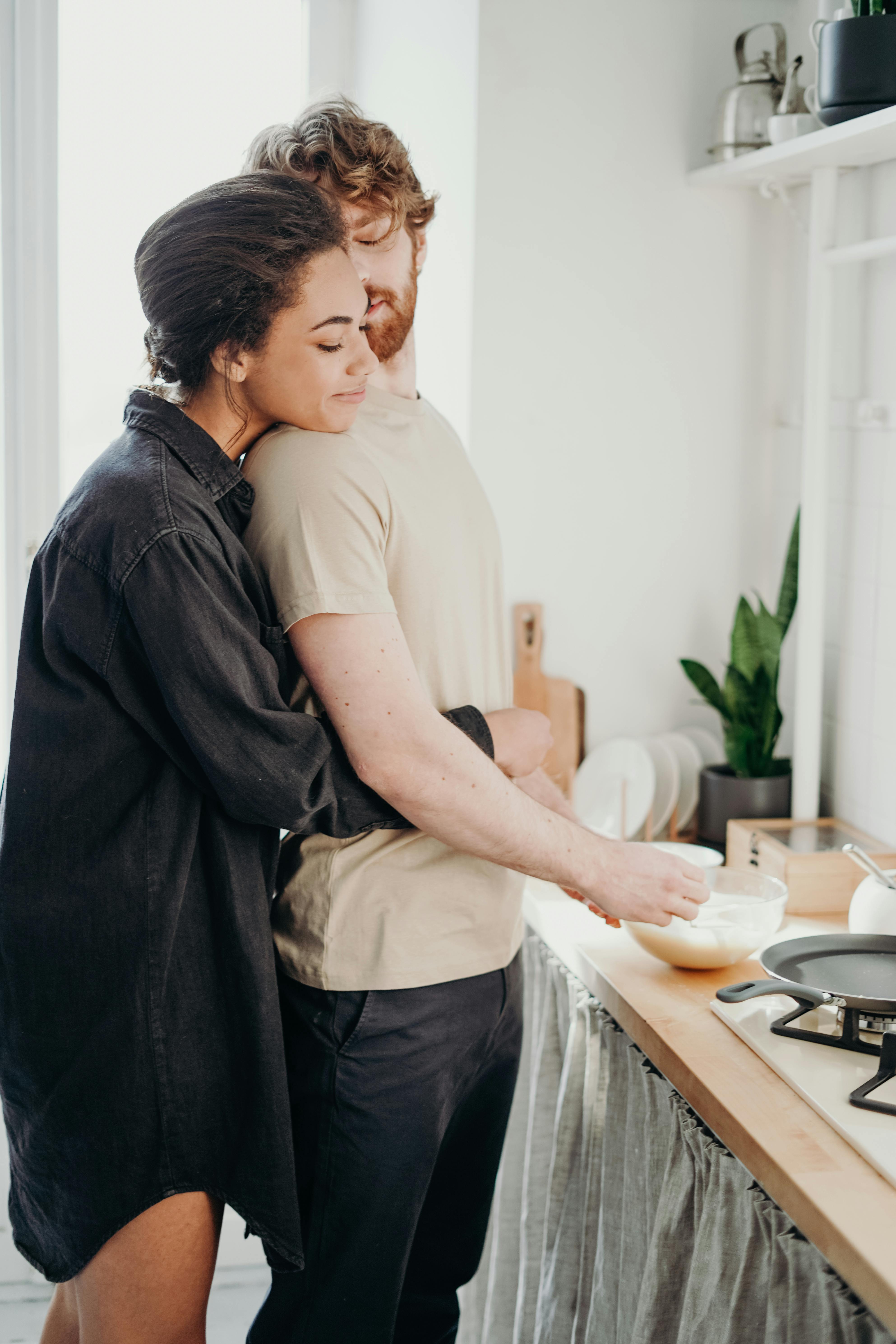 A couple enjoying each other's company in the kitchen | Source: Pexels