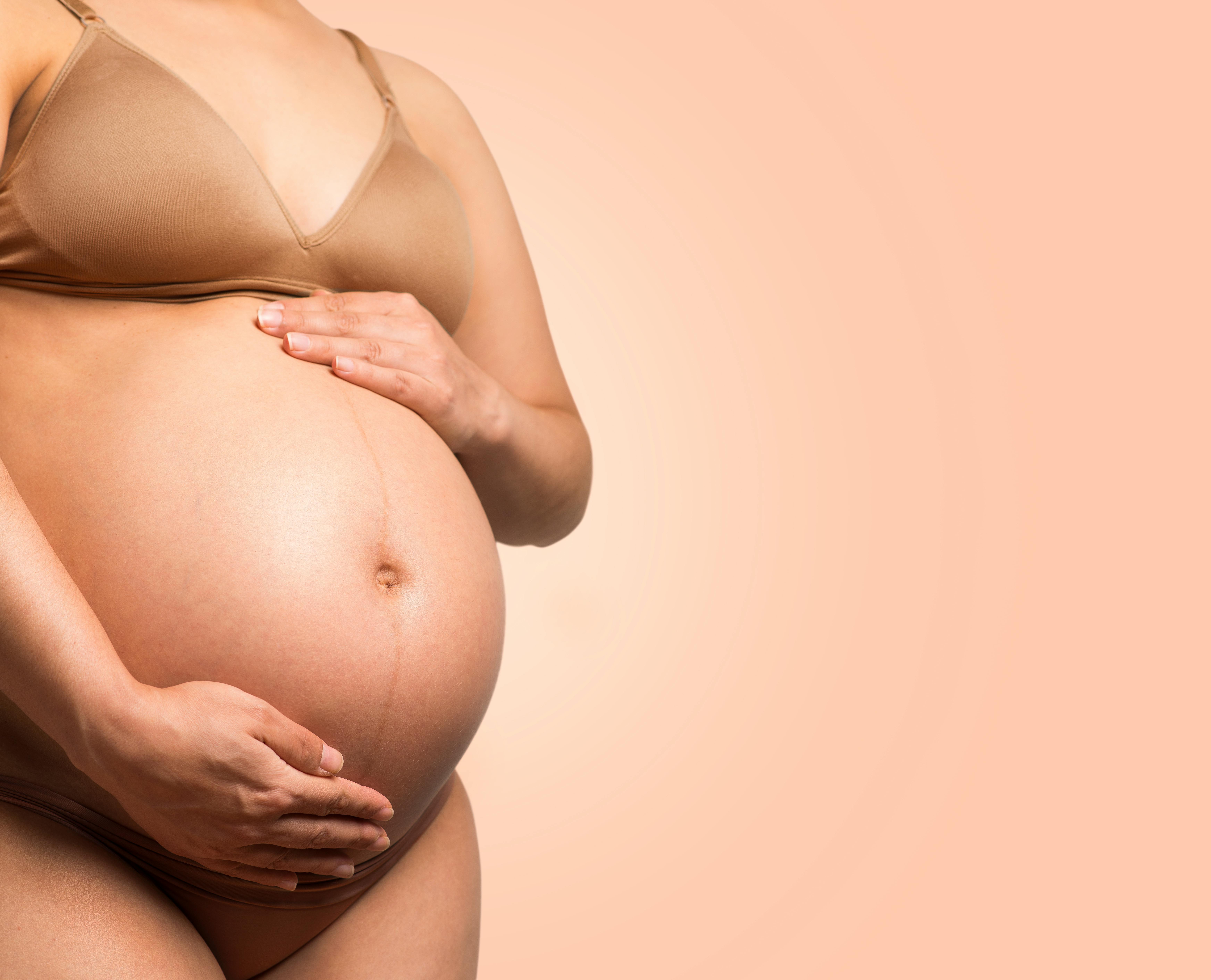 A pregnant woman cradling her baby bump. | Source: Pexels