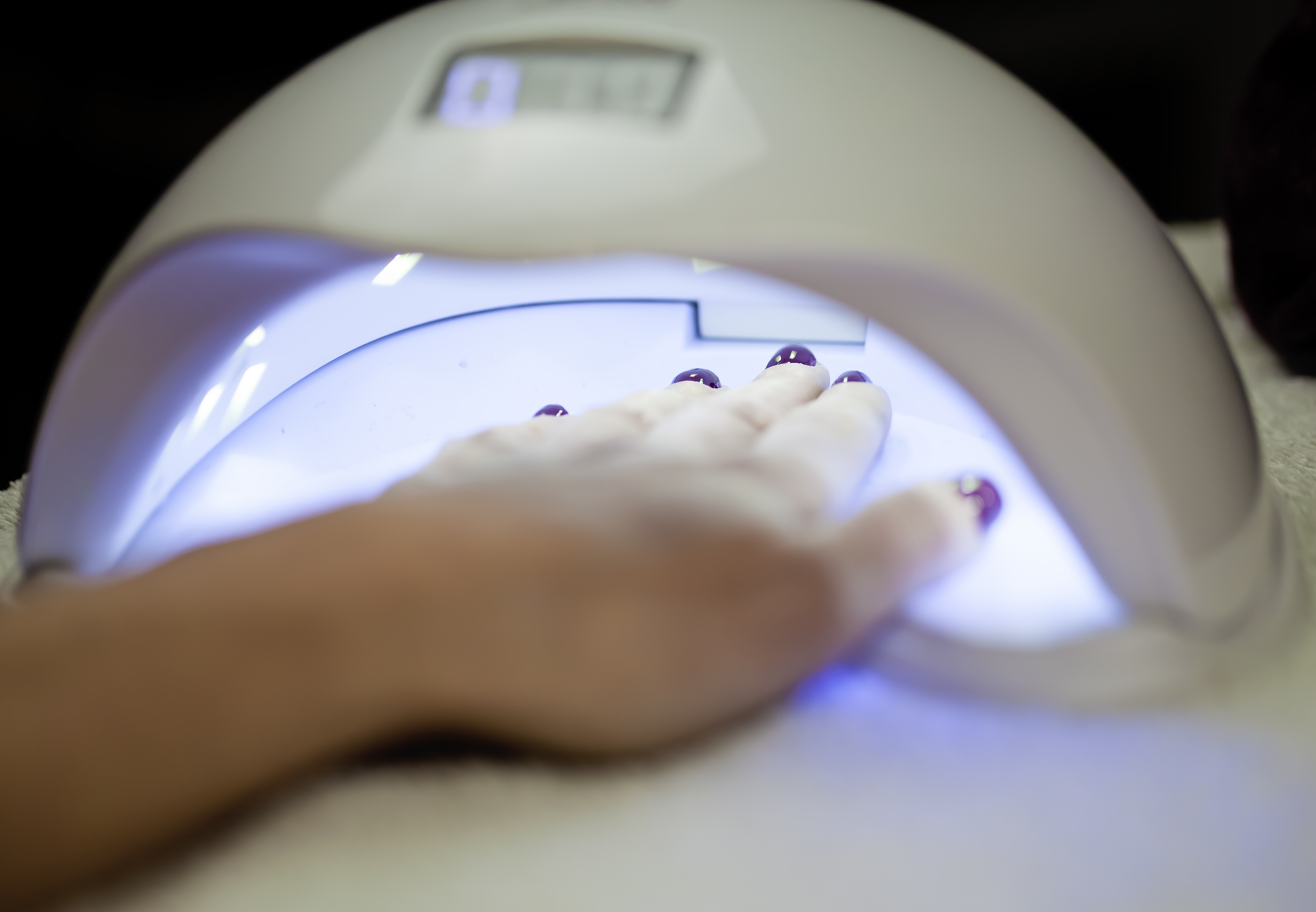 Nails drying under a UV light. | Source: Getty Images