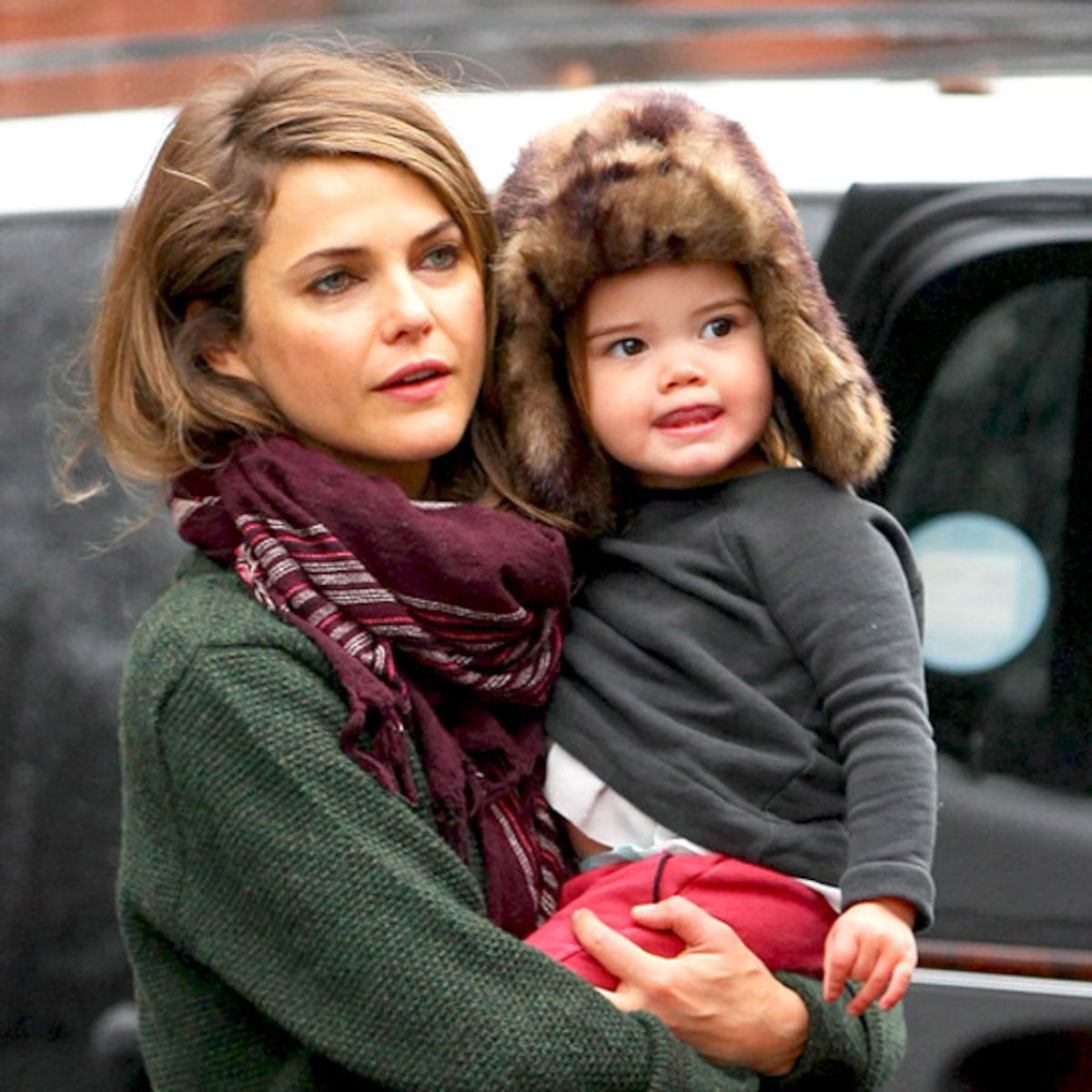 This earlier candid moment captures the mother carrying her daughter when she was still very young, offering a striking contrast to the teenager now appearing confidently beside her at major fashion events. | Source: Getty Images