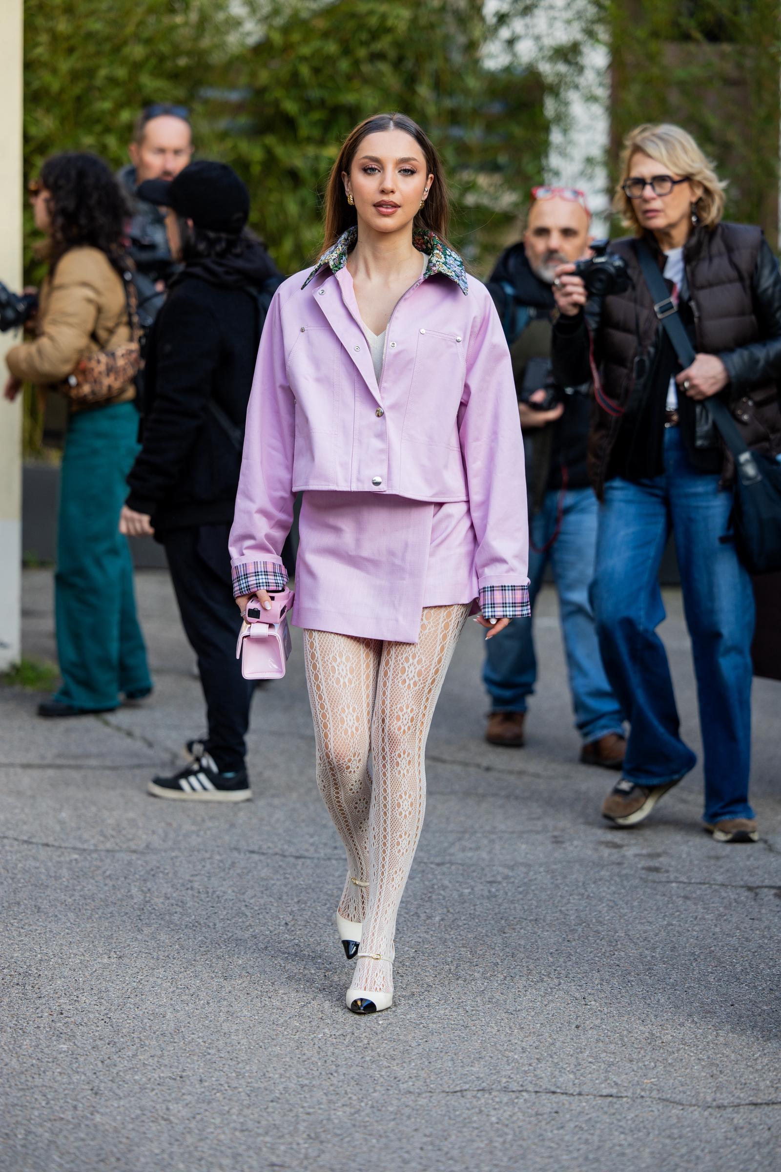 A woman wearing a lilac ensemble wth lace tights uring the Milan Fashion Week - Womenswear Fall/Winter 2026/2027 on February 28, 2026 | Source: Getty Images