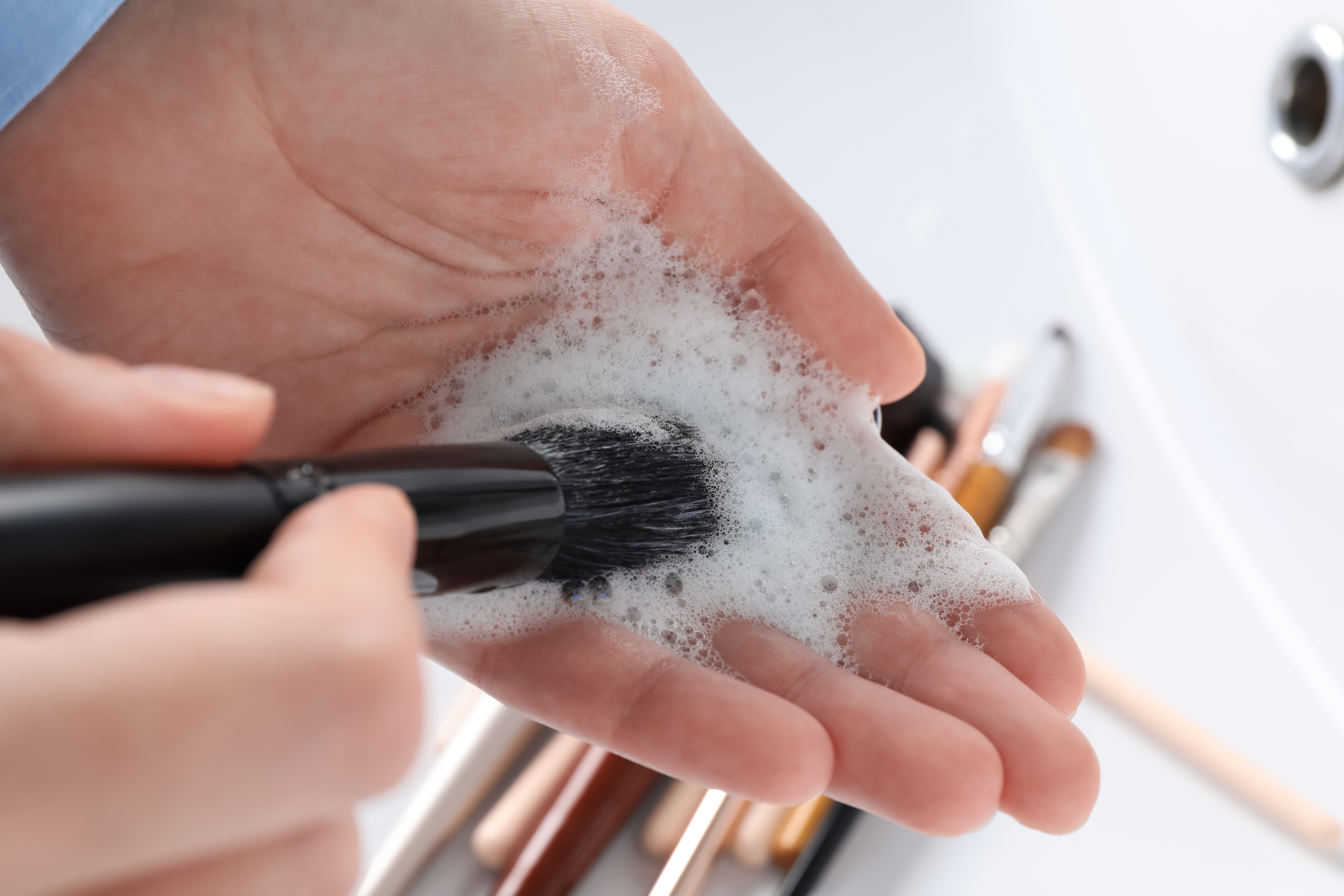A close-up photo of a person washing their makeup brushes | Source: Shutterstock
