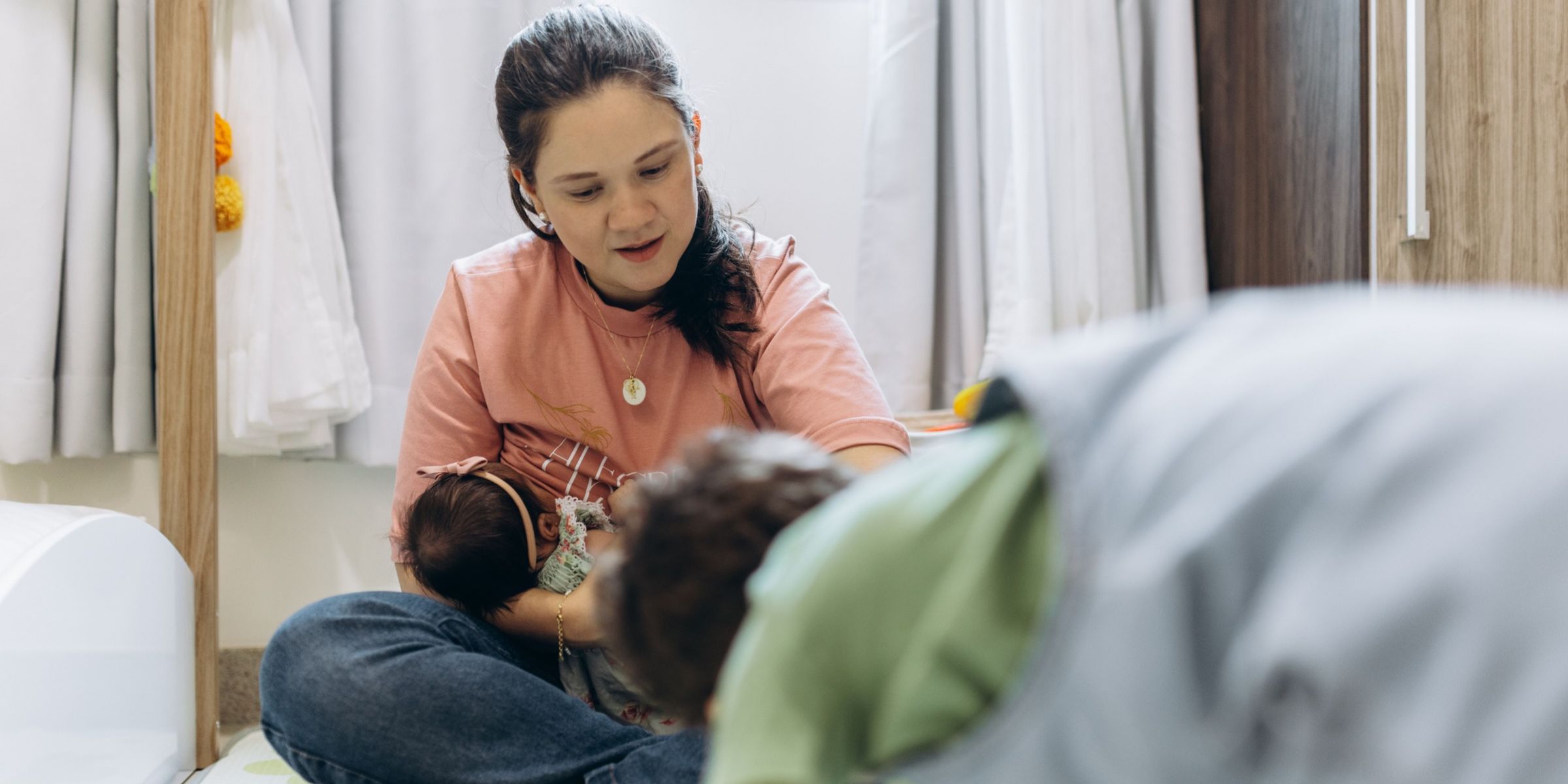 A woman sitting on the floor and holding a baby | Source: Pexels