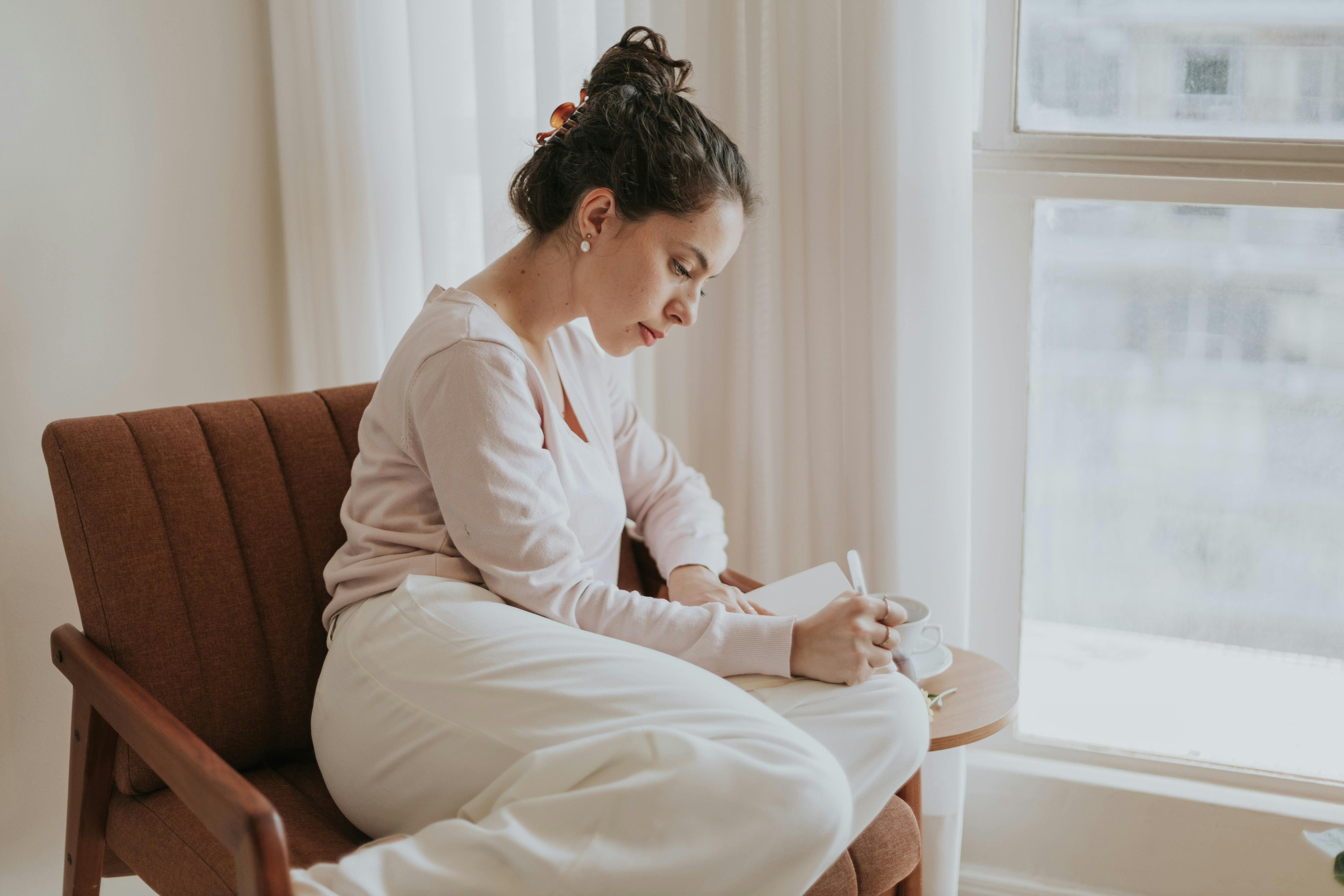 A woman journaling | Source: Pexels