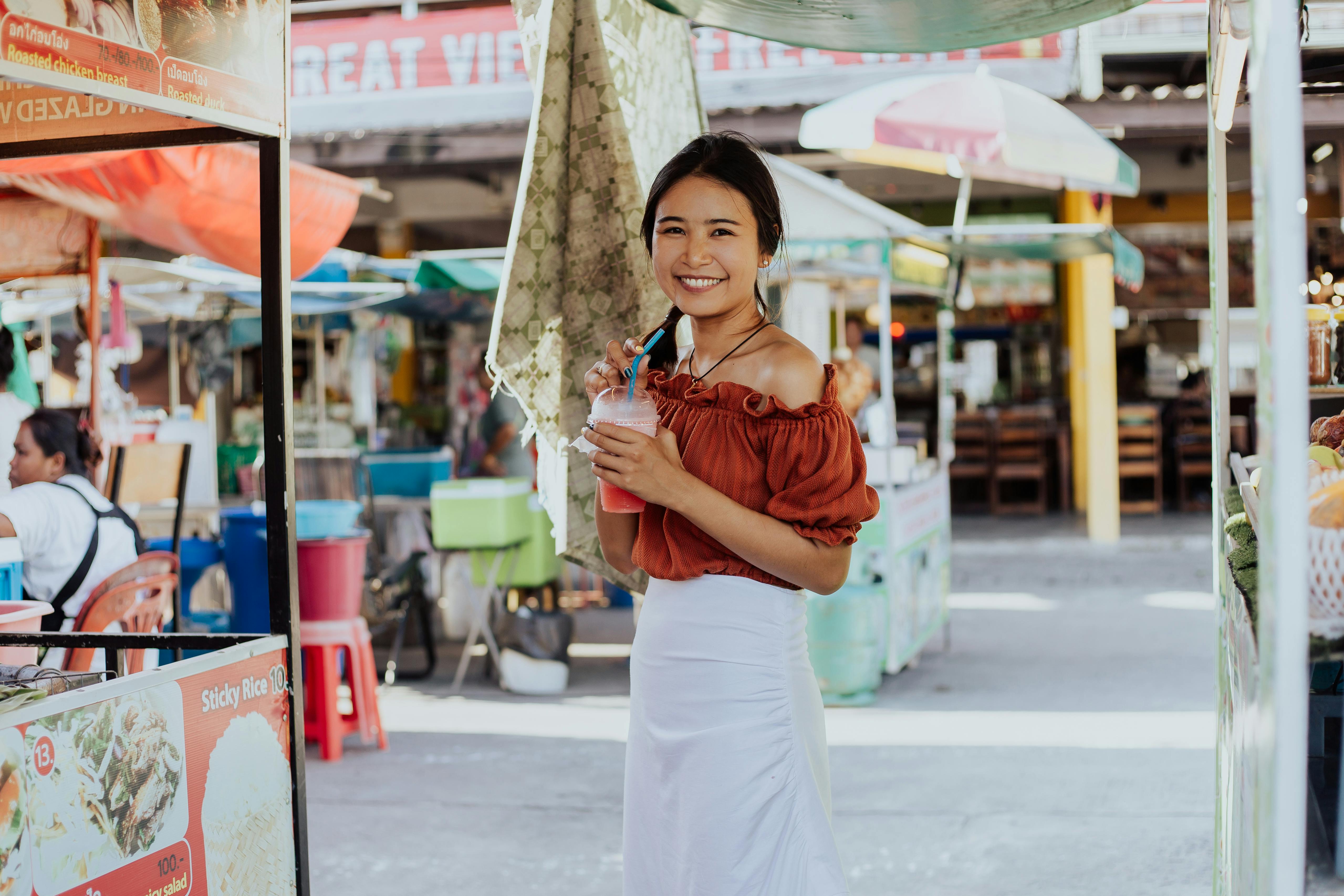 Woman smiling while holding a smoothie | Source: Pexels
