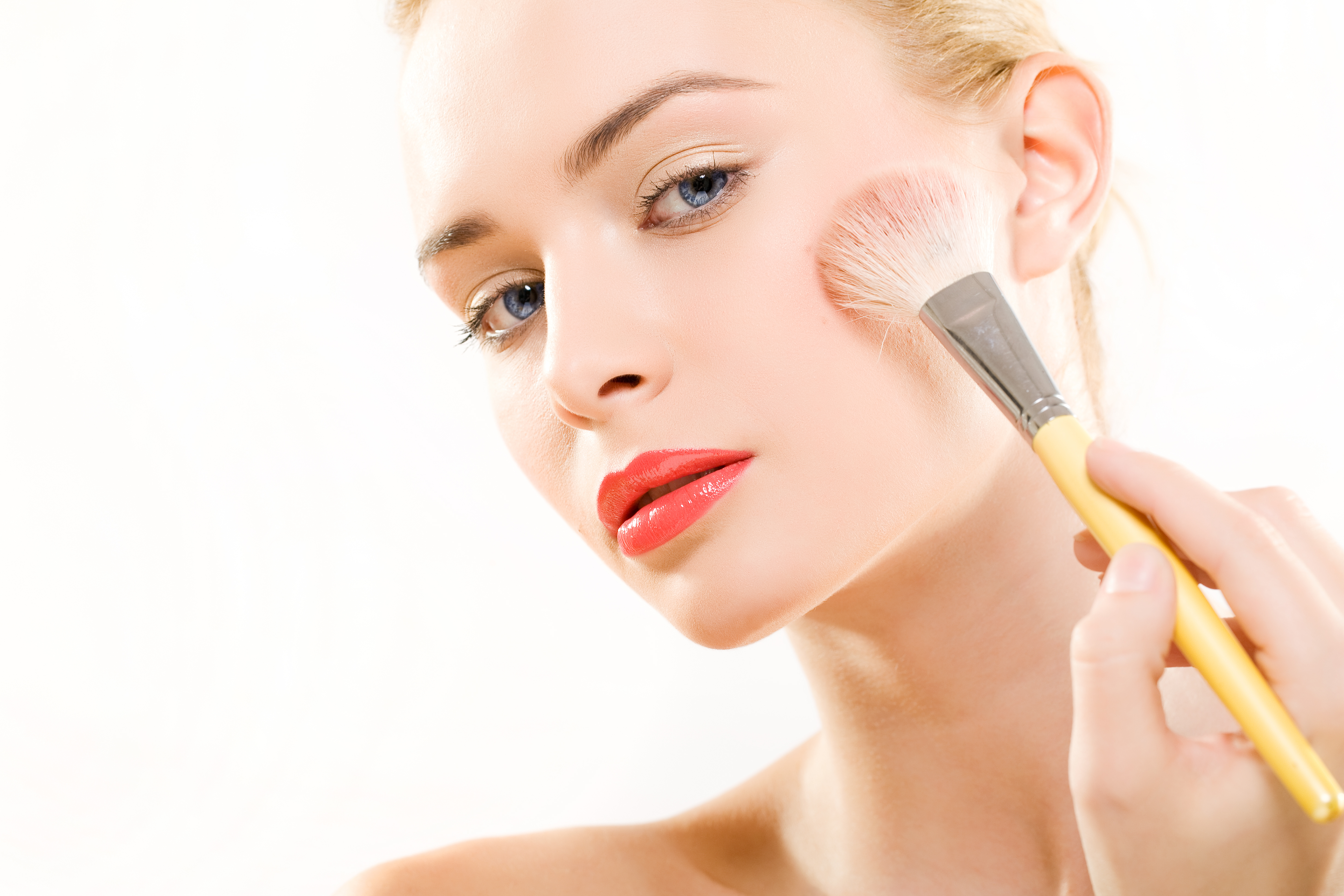 Woman applying powder foundation. | Source: Getty Images