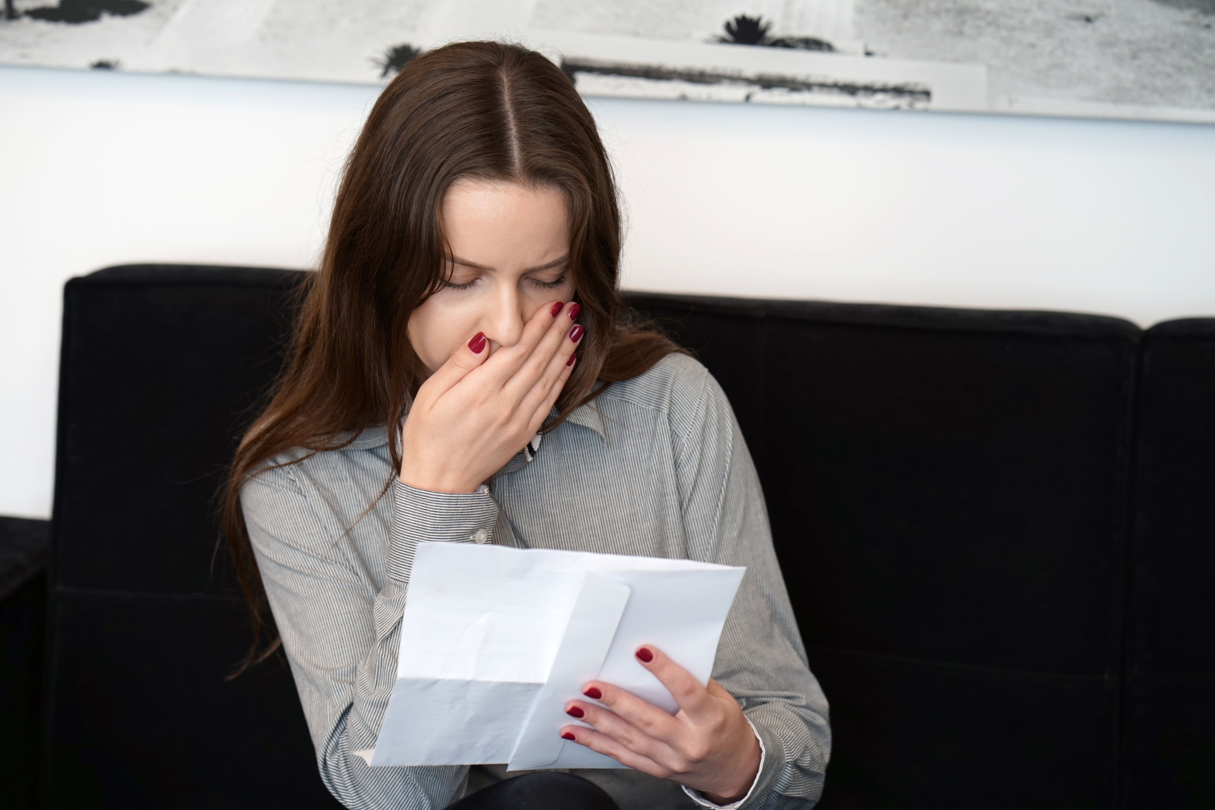 A woman reading an upsetting letter | Source: Getty Images