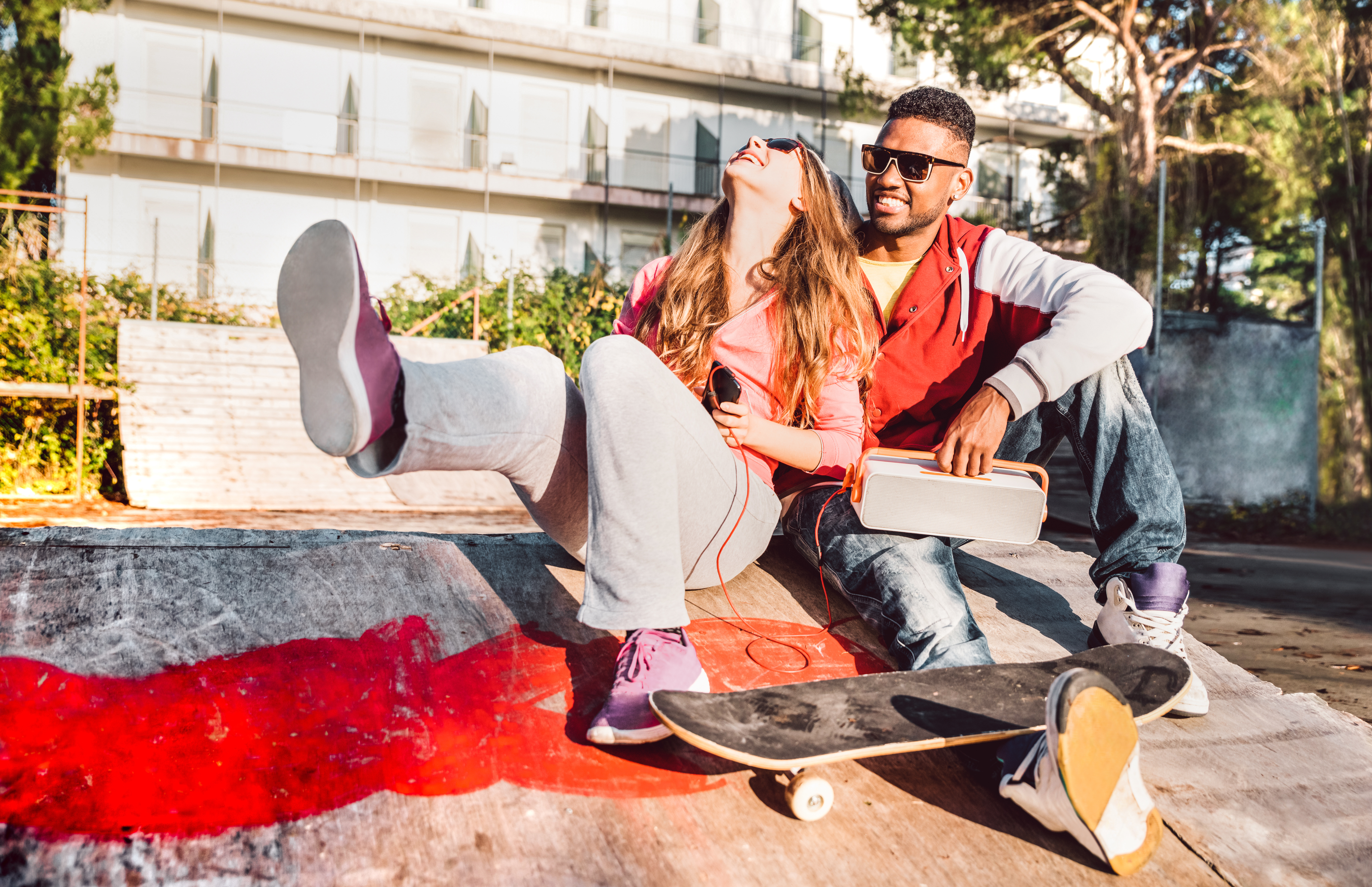 Two young people hanging out at a skate park. | Source Getty Images
