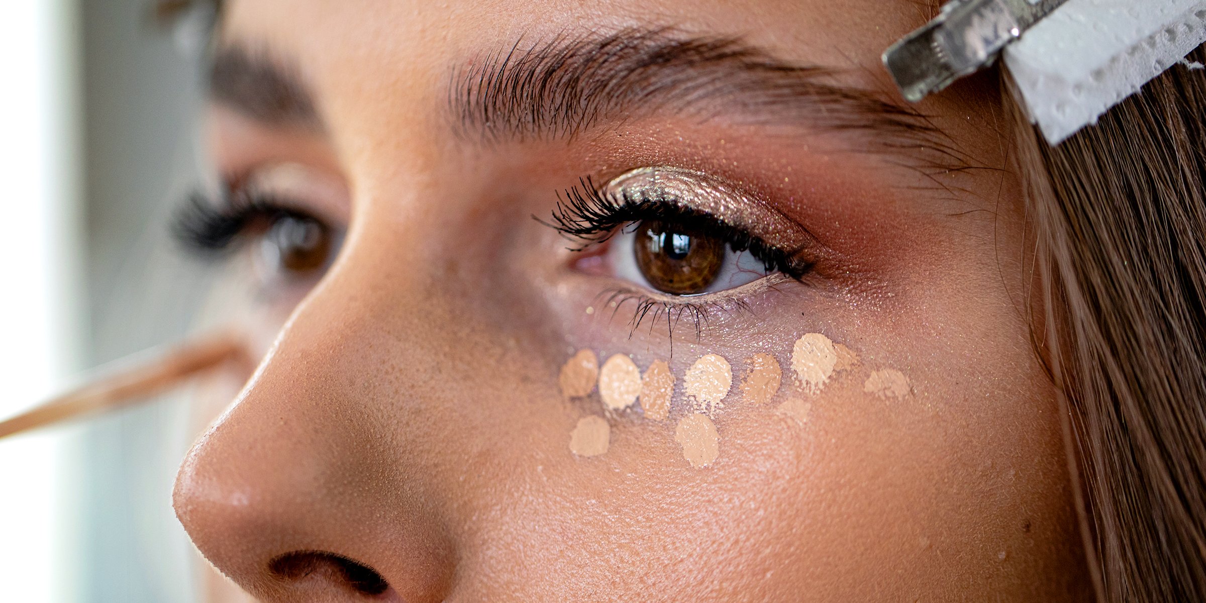 Woman applying concealer. | Source: Getty Images