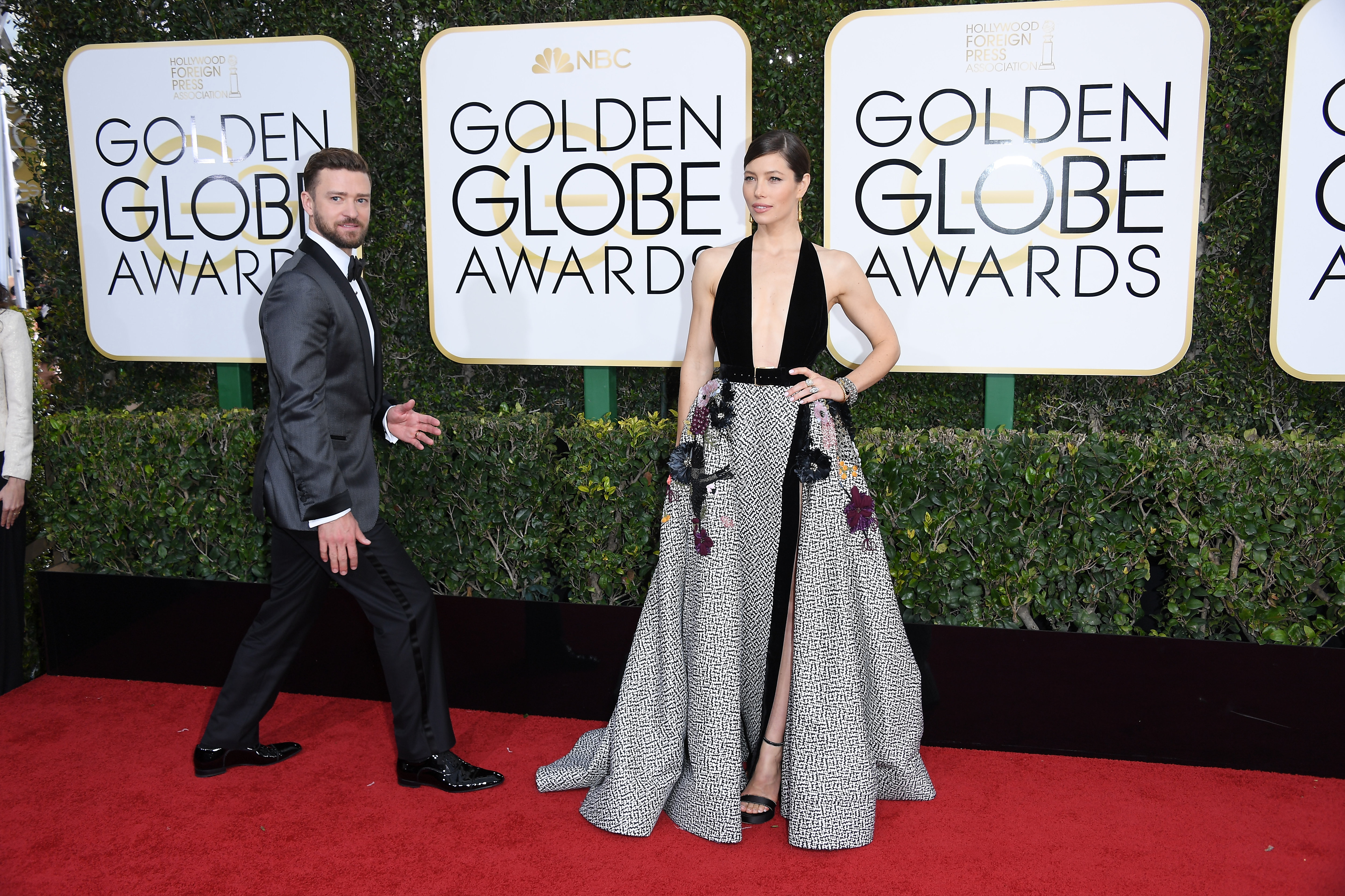 Justin Timberlake walks alongside Jessica Biel on the red carpet at the Golden Globe Awards. Biel stands out in a plunging black halter top paired with a voluminous black-and-white patterned skirt, while Timberlake wears a gray tuxedo.