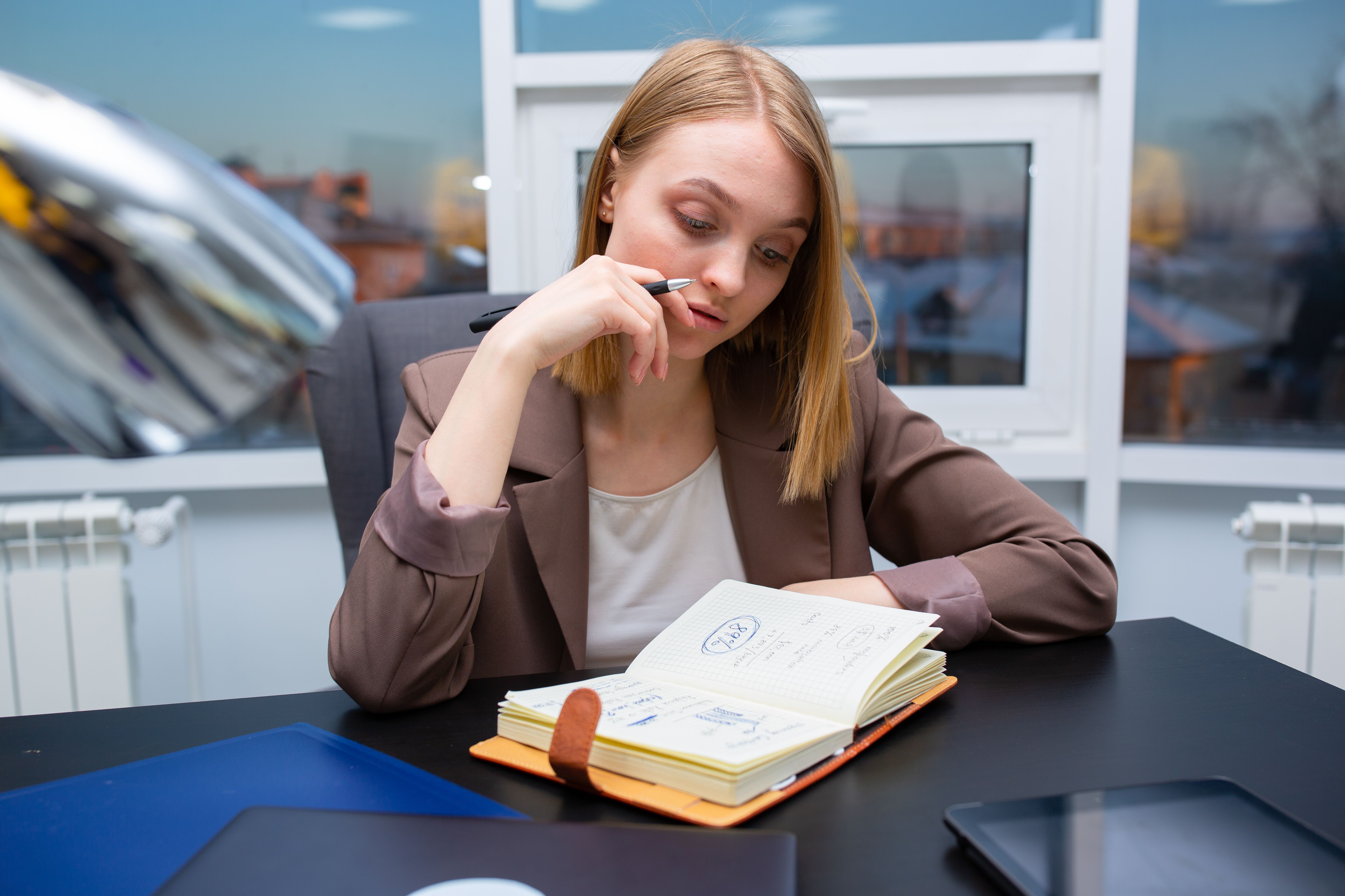 Woman planning her schedule in the office | Source: Pexels