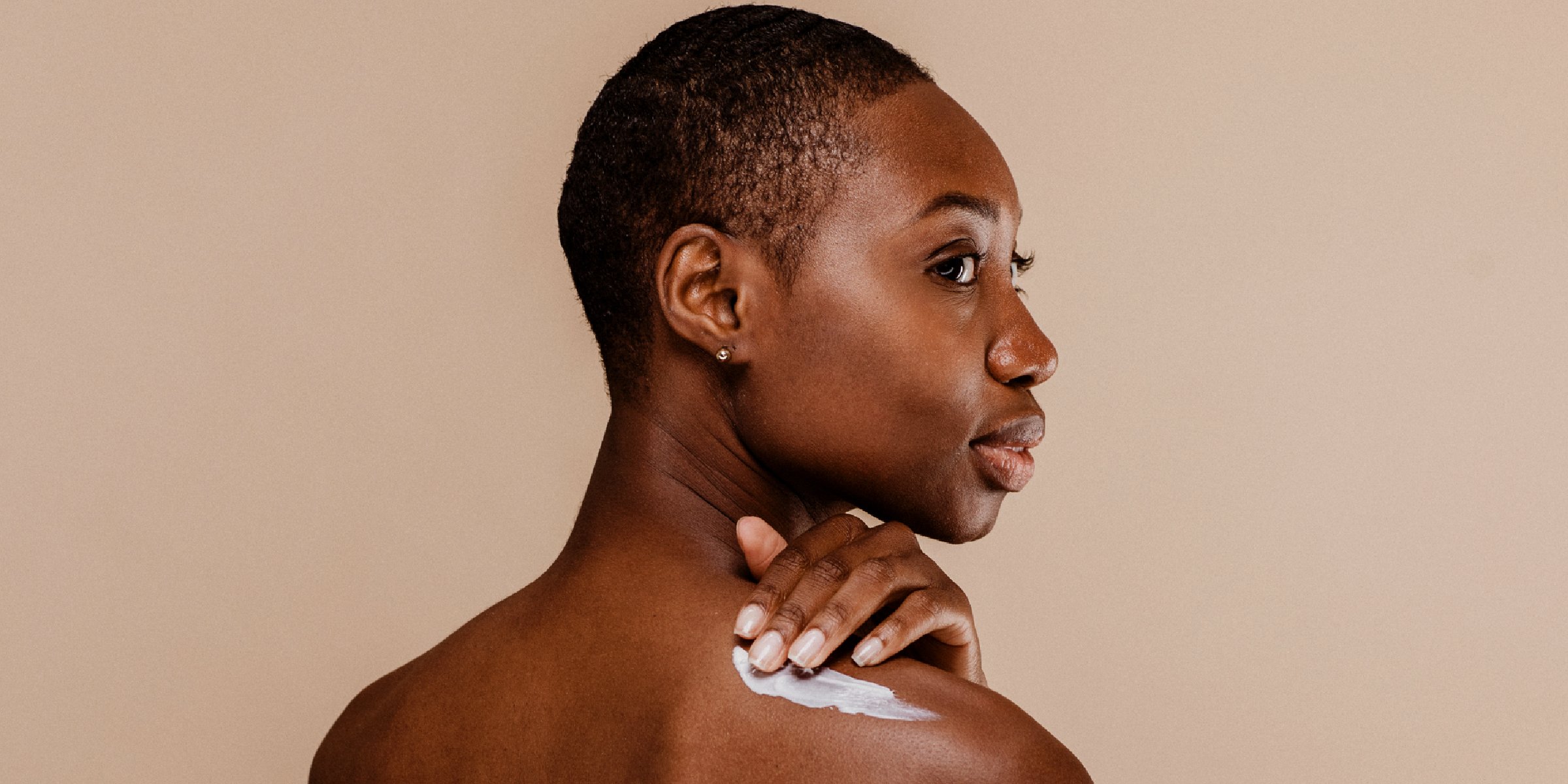 Woman applying body cream | Source: Shutterstock