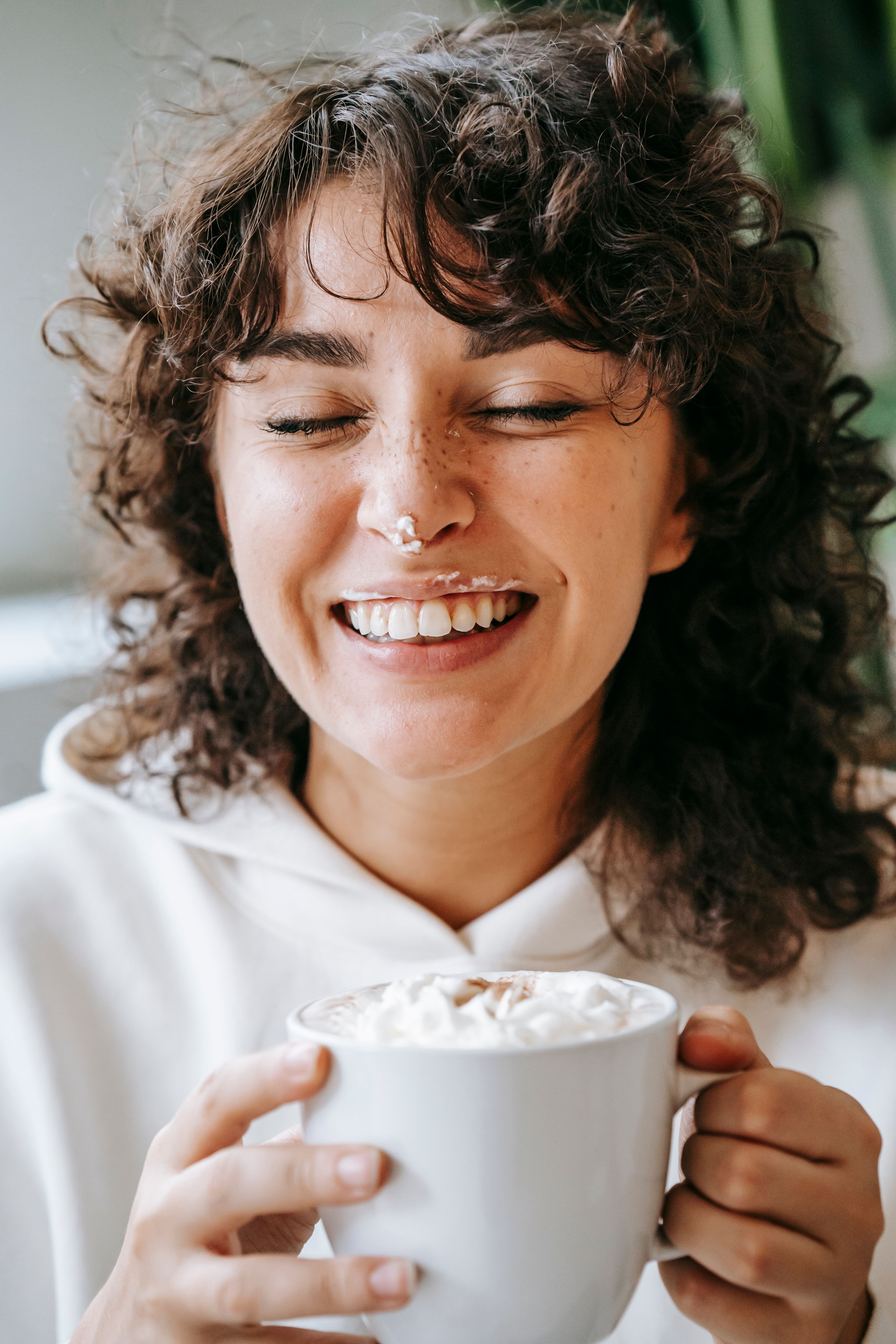 A woman enjoying her coffee as foam gets on her nose and upper lip | Source: Pexels