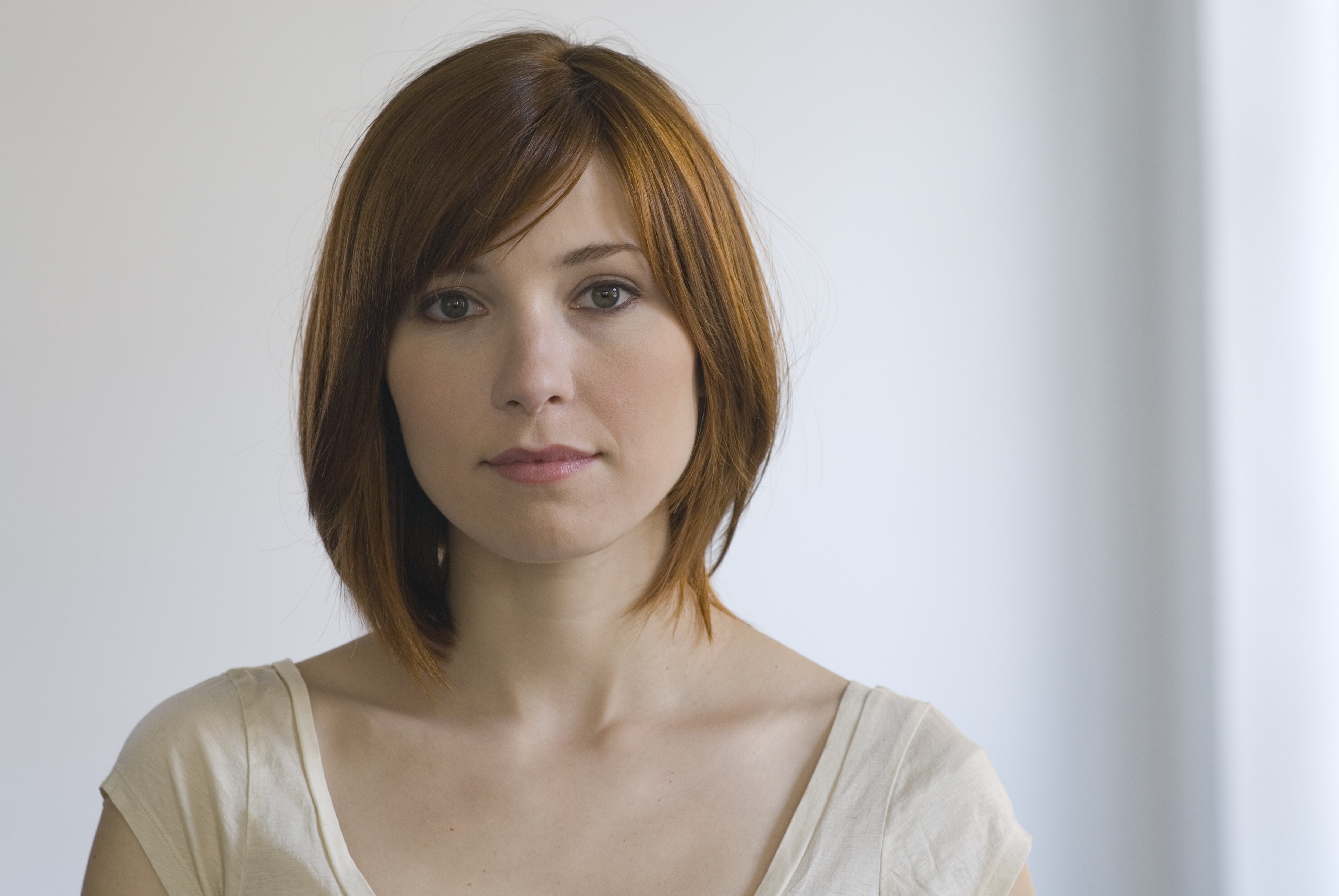 A portrait of a woman with red hair styled in sideways curtain bangs | Source: Getty Images