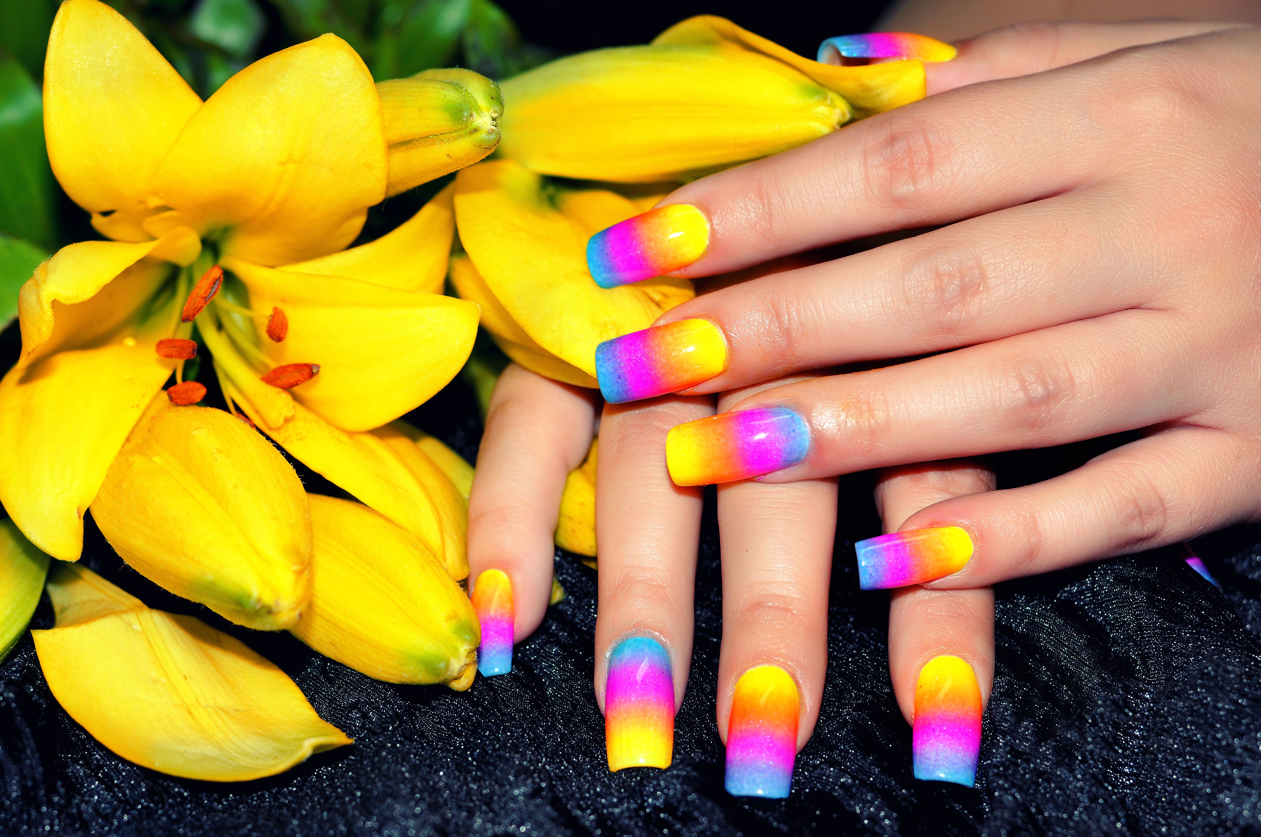 Rainbow-colored nails and yellow flowers. | Source: Getty Images