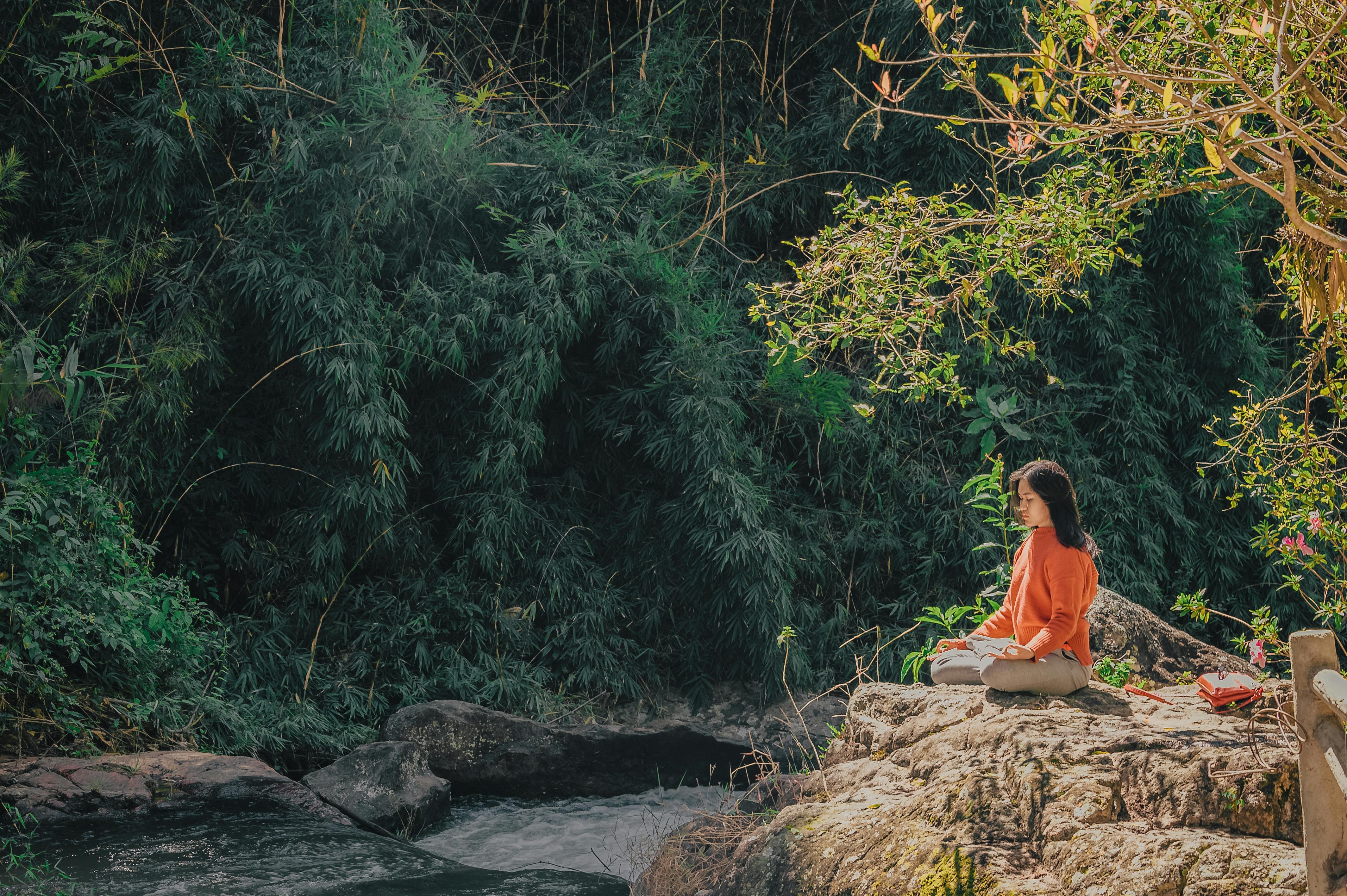 A woman meditates outdoors. | Source: Pexels