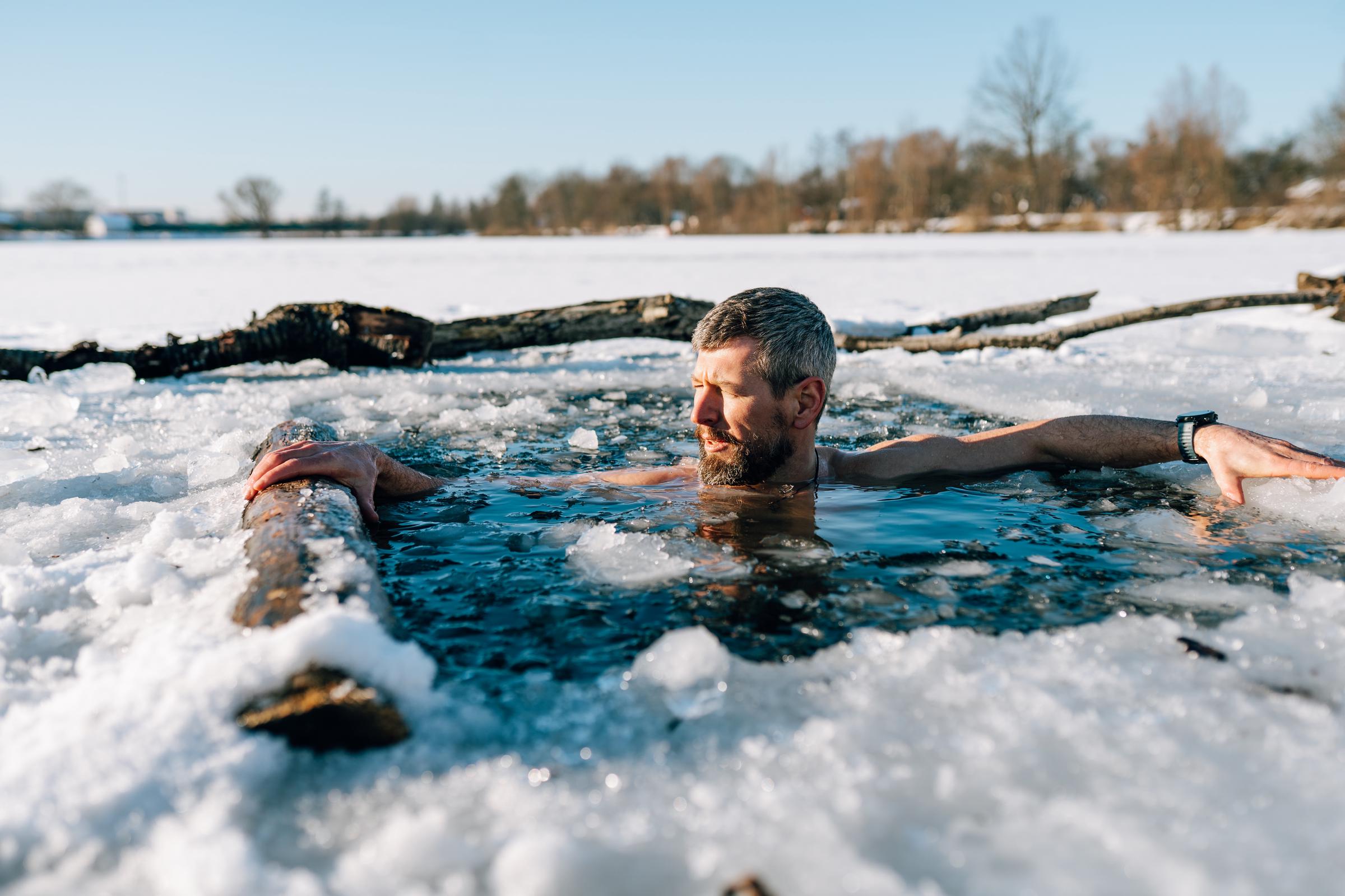 A man immerses himself in a cold lake during winter | Source: Getty Images