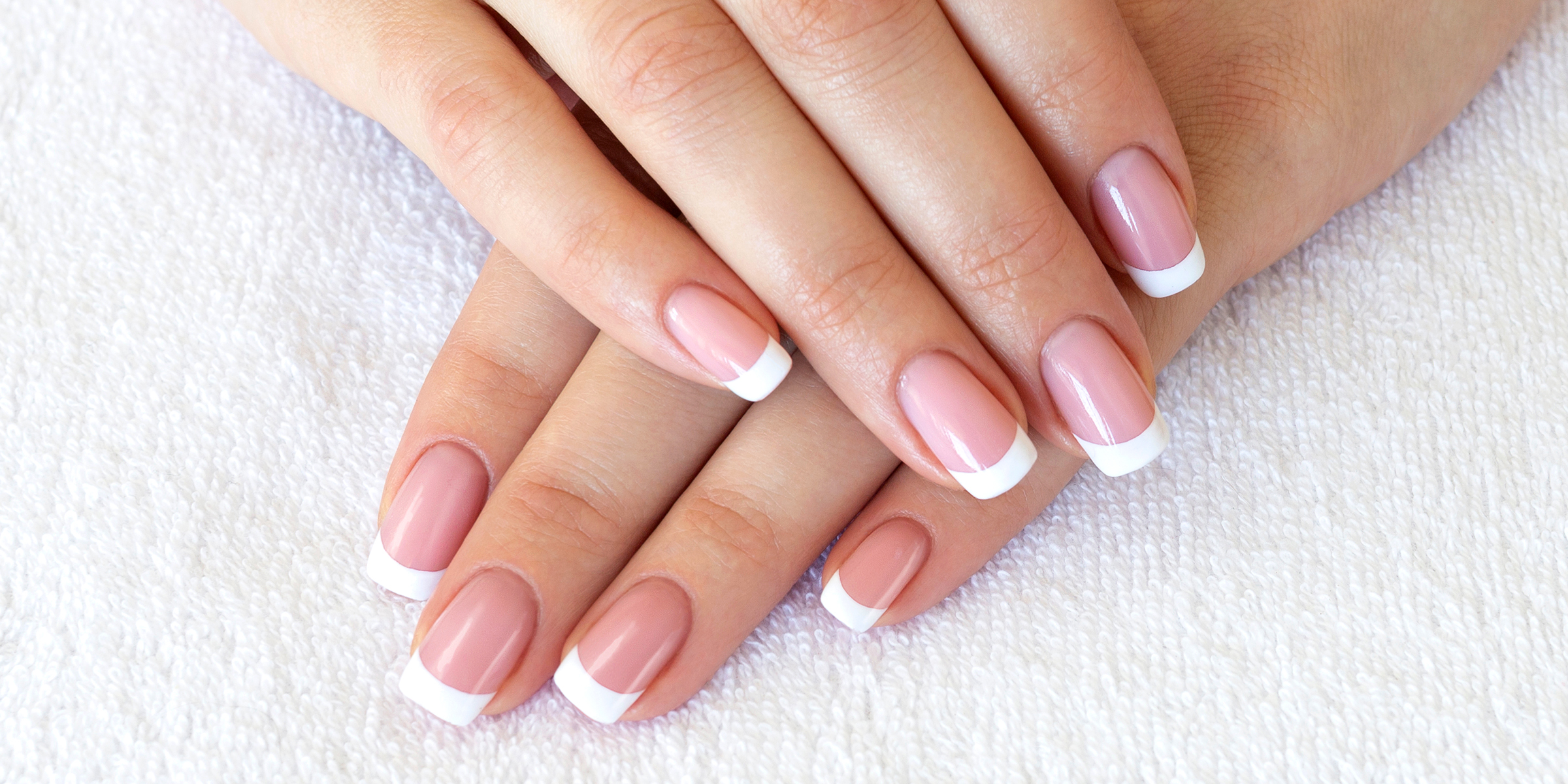 A close-up image of hands with a French manicure. | Source: Shutterstock