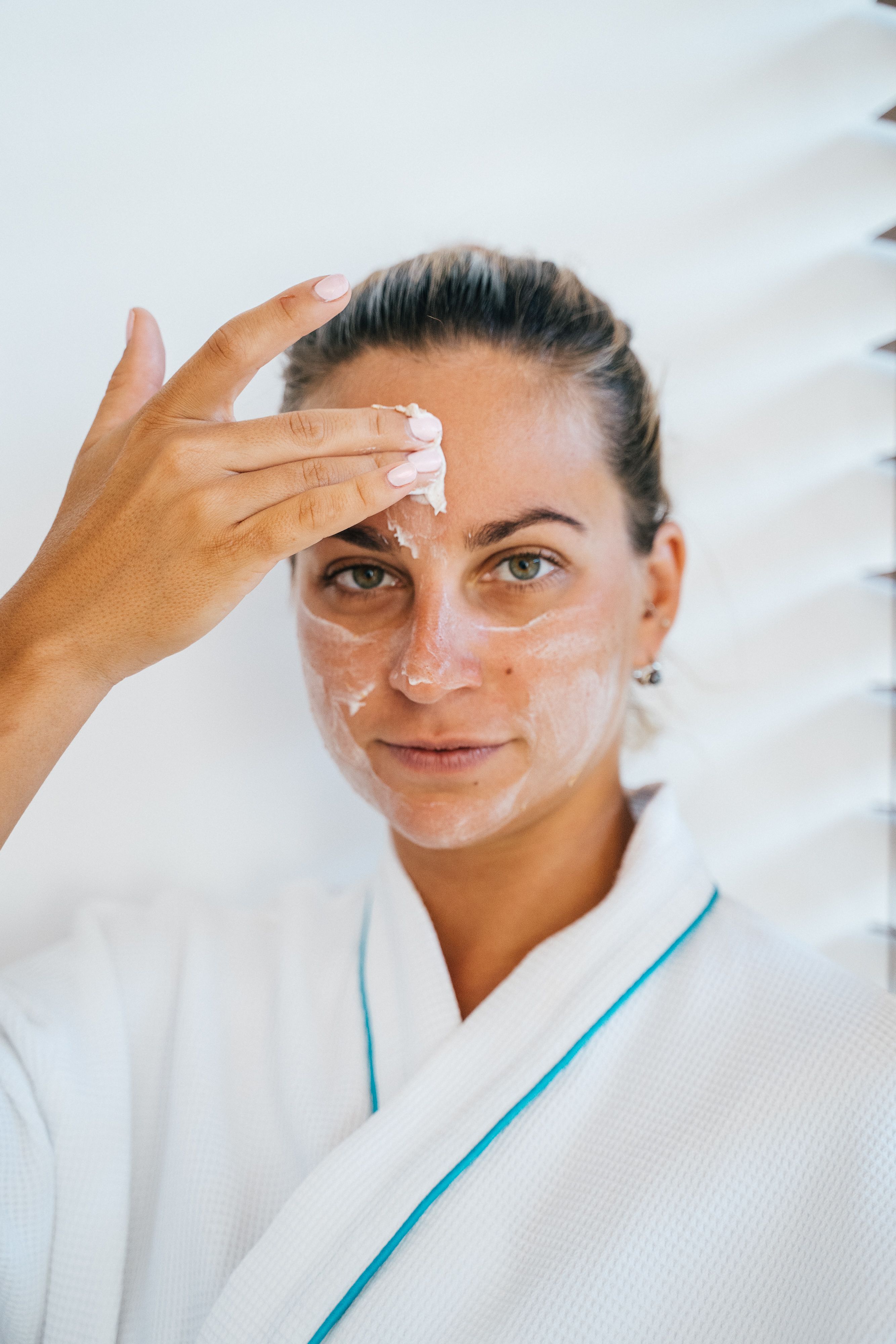 Woman applying cream on her face | Source: Pexels