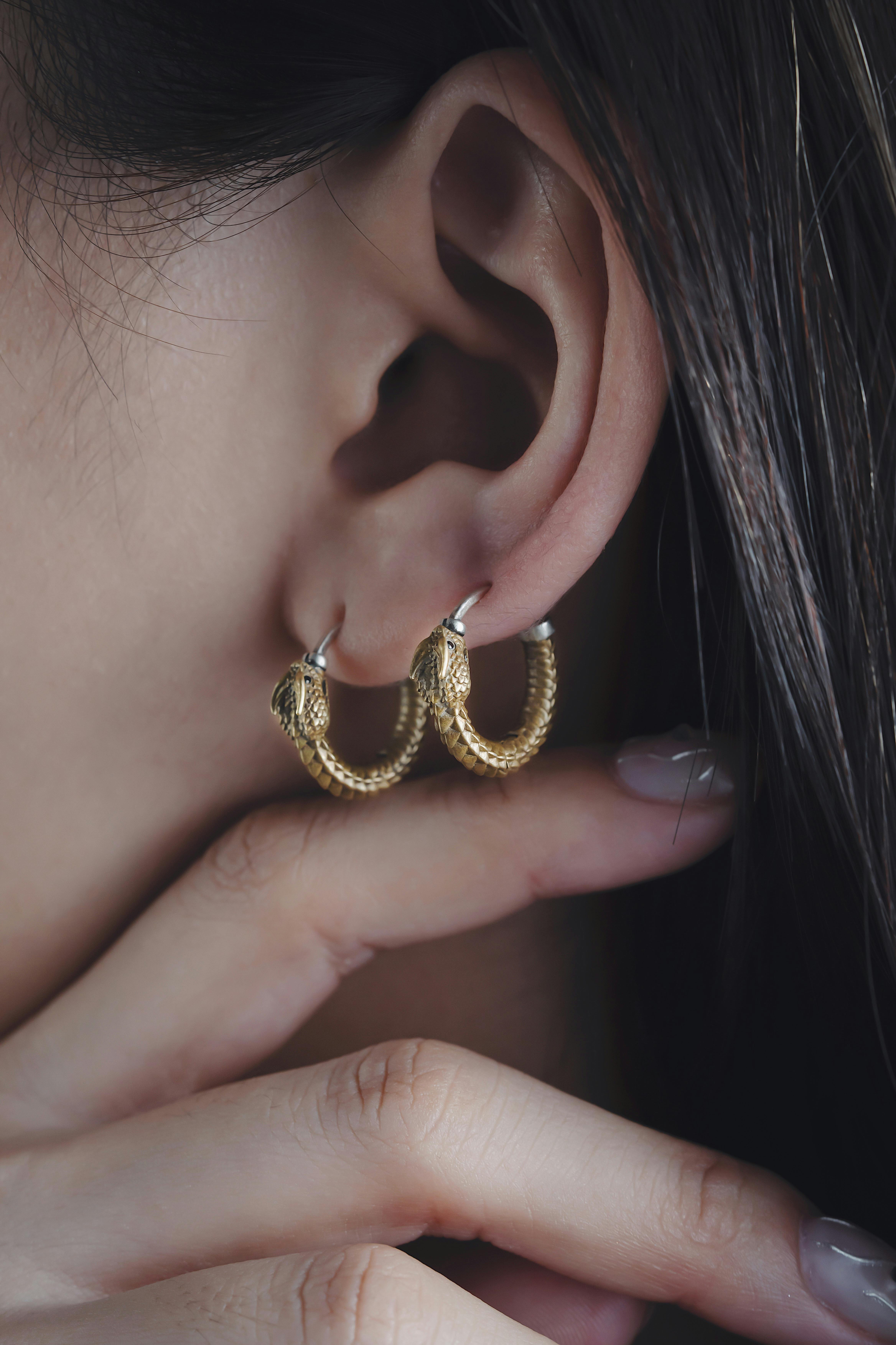 A woman wearing gold hoop earrings | Source: Pexels