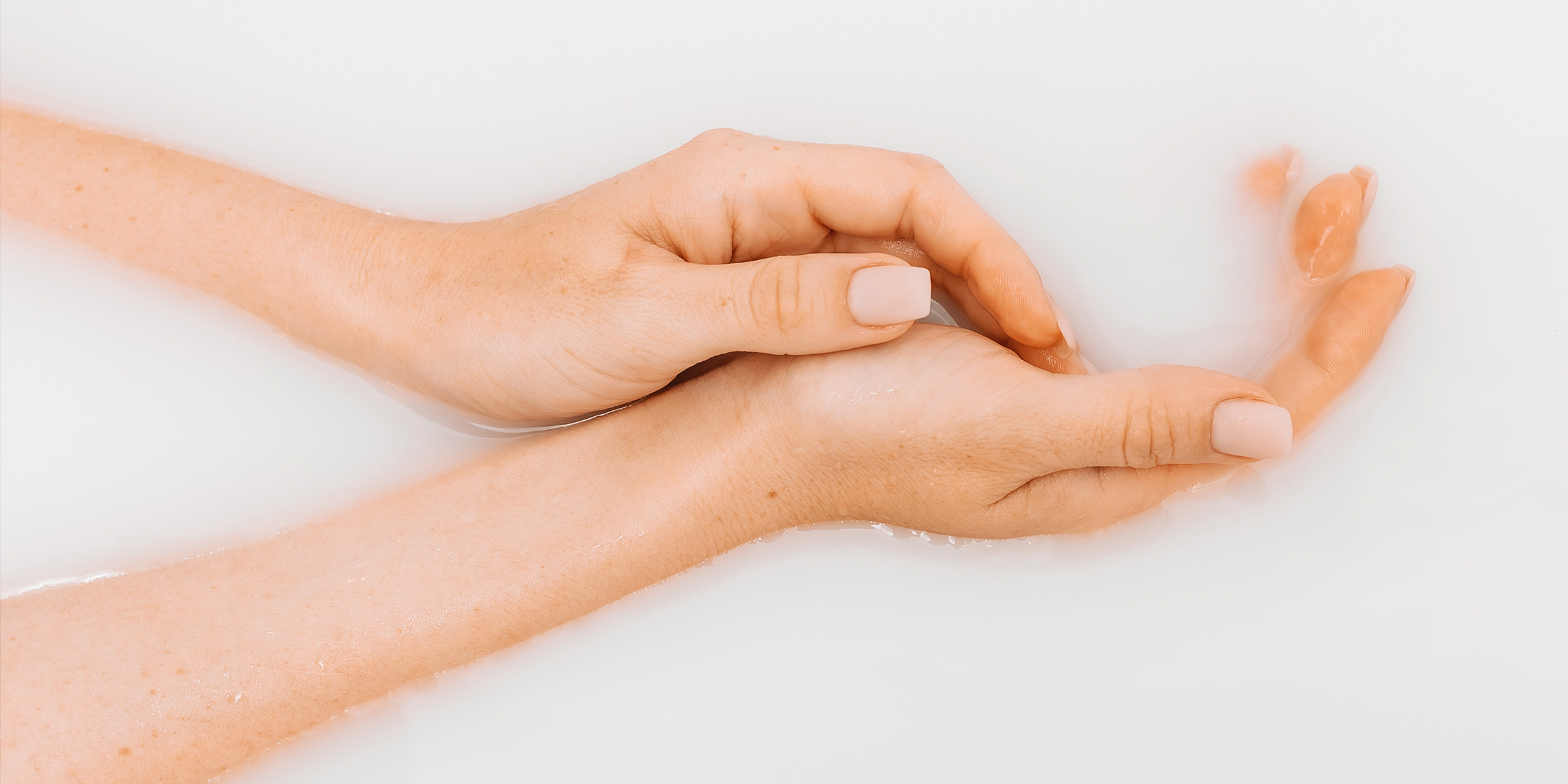 Hands in milk bath | Source: Shutterstock