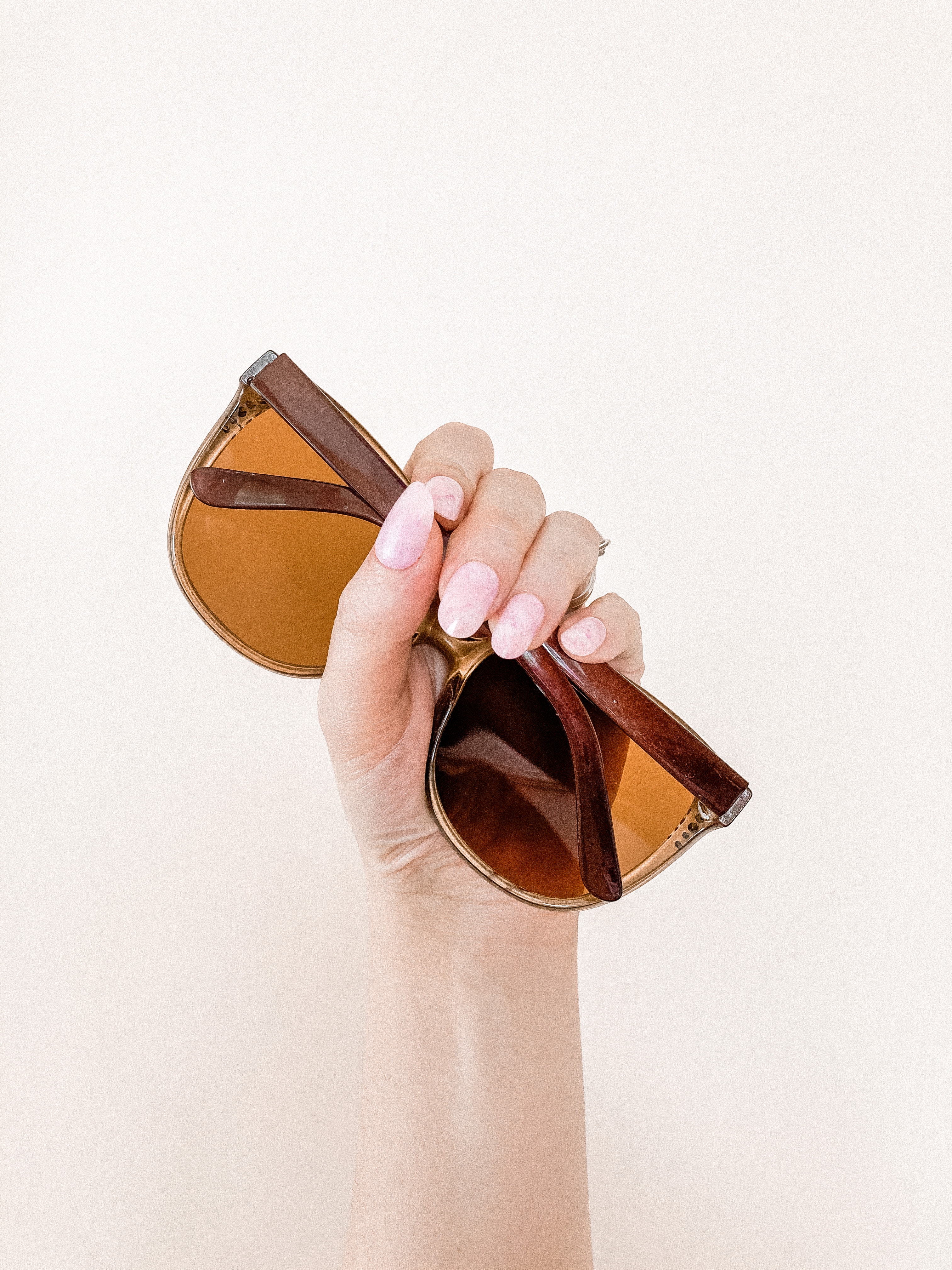 An image of a hand holding a sunglasses. | Source: pexels