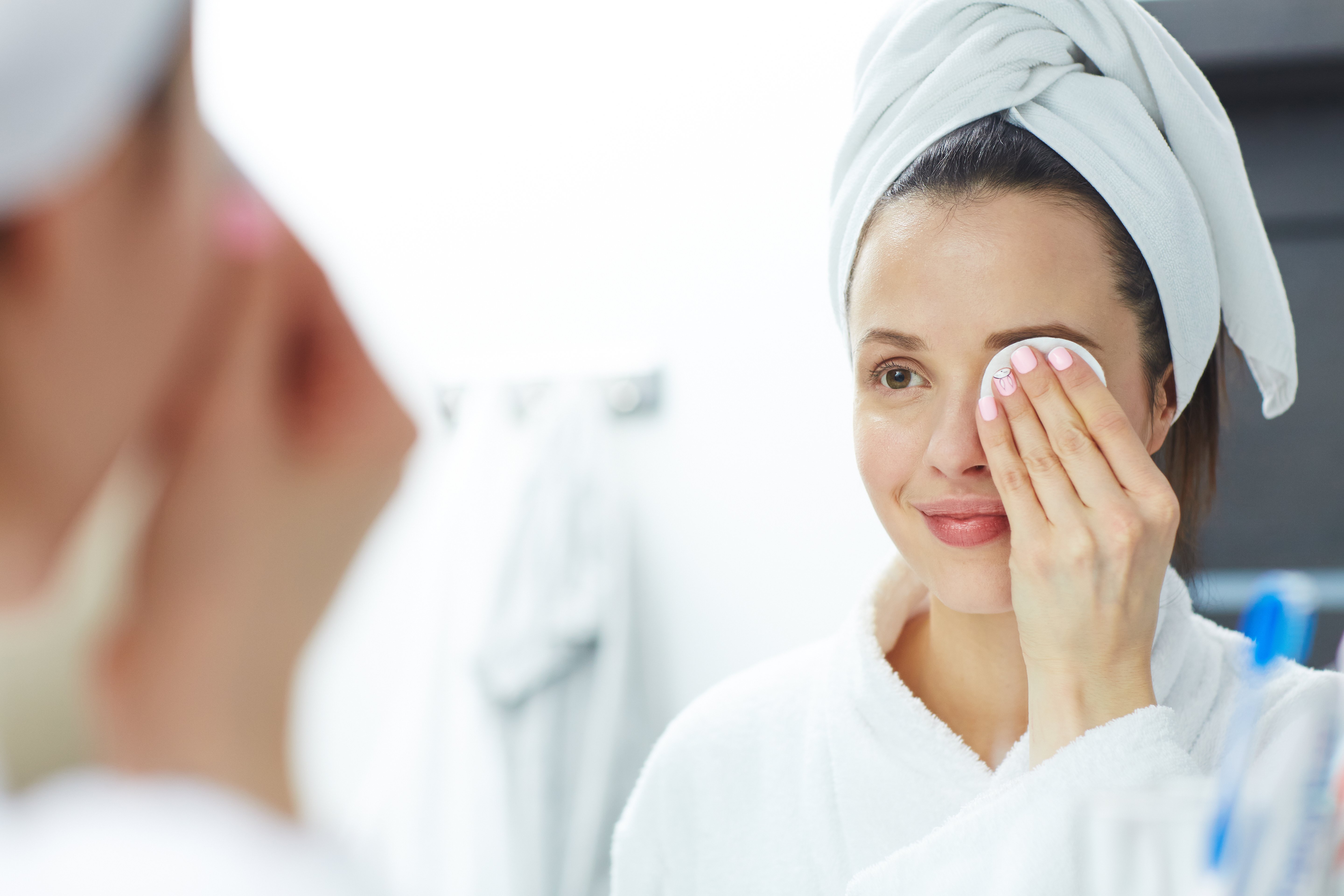 Woman removing her makeup with a cotton pad. | Source: Getty Images