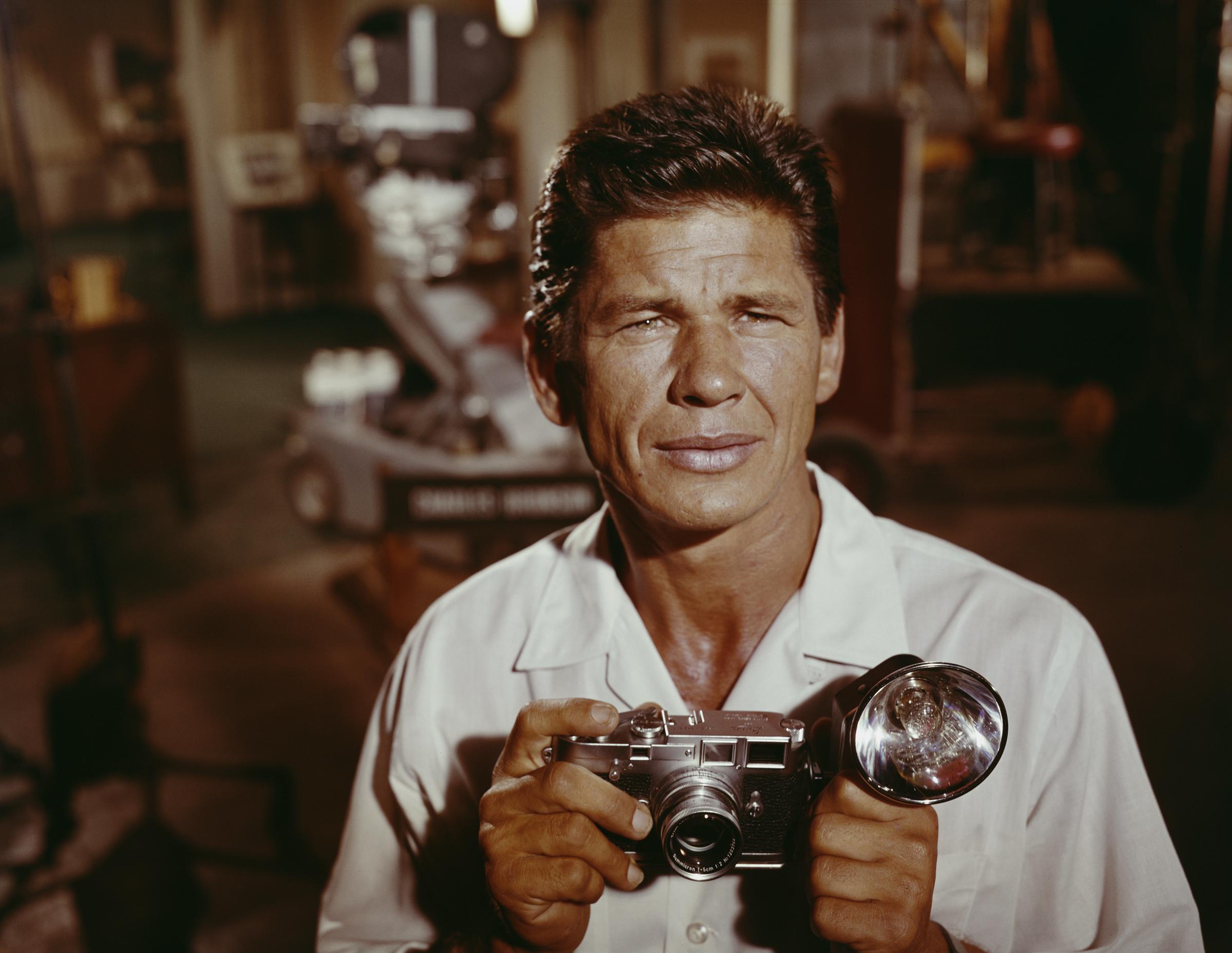 Charles Bronson poses with a camera on a film set circa 1958, years before "Death Wish" cemented his status as a Hollywood tough guy. | Source: Getty Images
