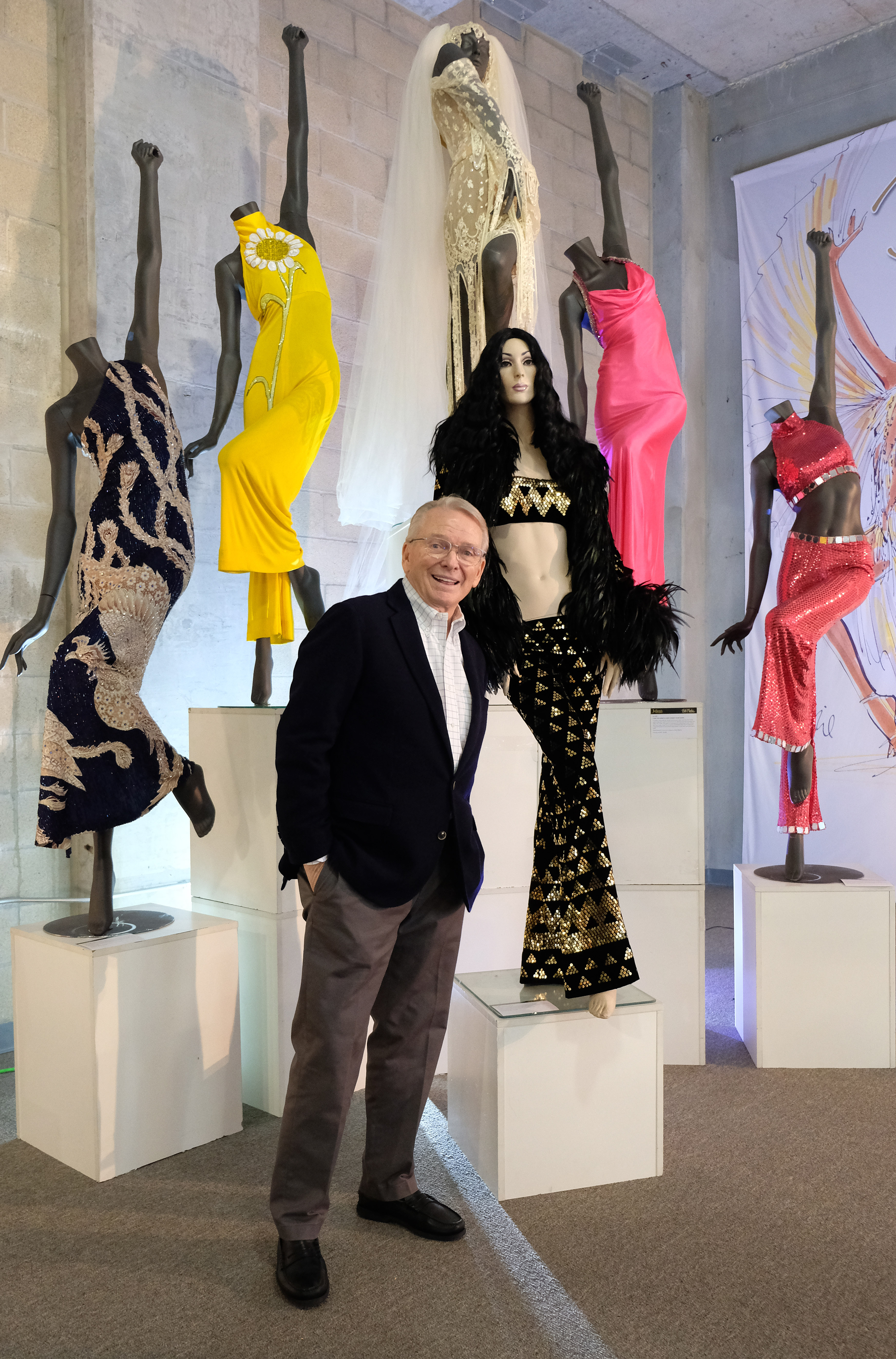 Bob Mackie poses with his designs at "Icons & Idols: Hollywood & Street Contemporary Art Auction" preview with Julien's Auctions on November 12, 2018 in Beverly Hills, California | Source: Getty Images