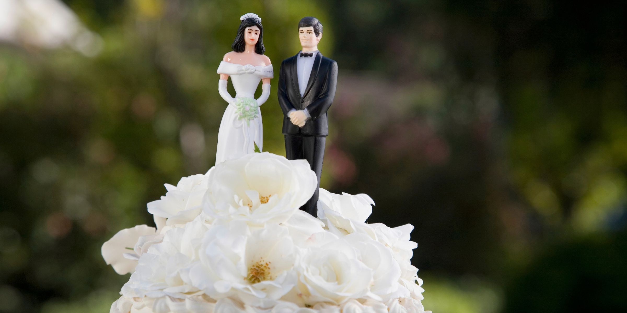 Close-up shot of a bride and groom figurines on top of wedding cake | Source: Getty Images
