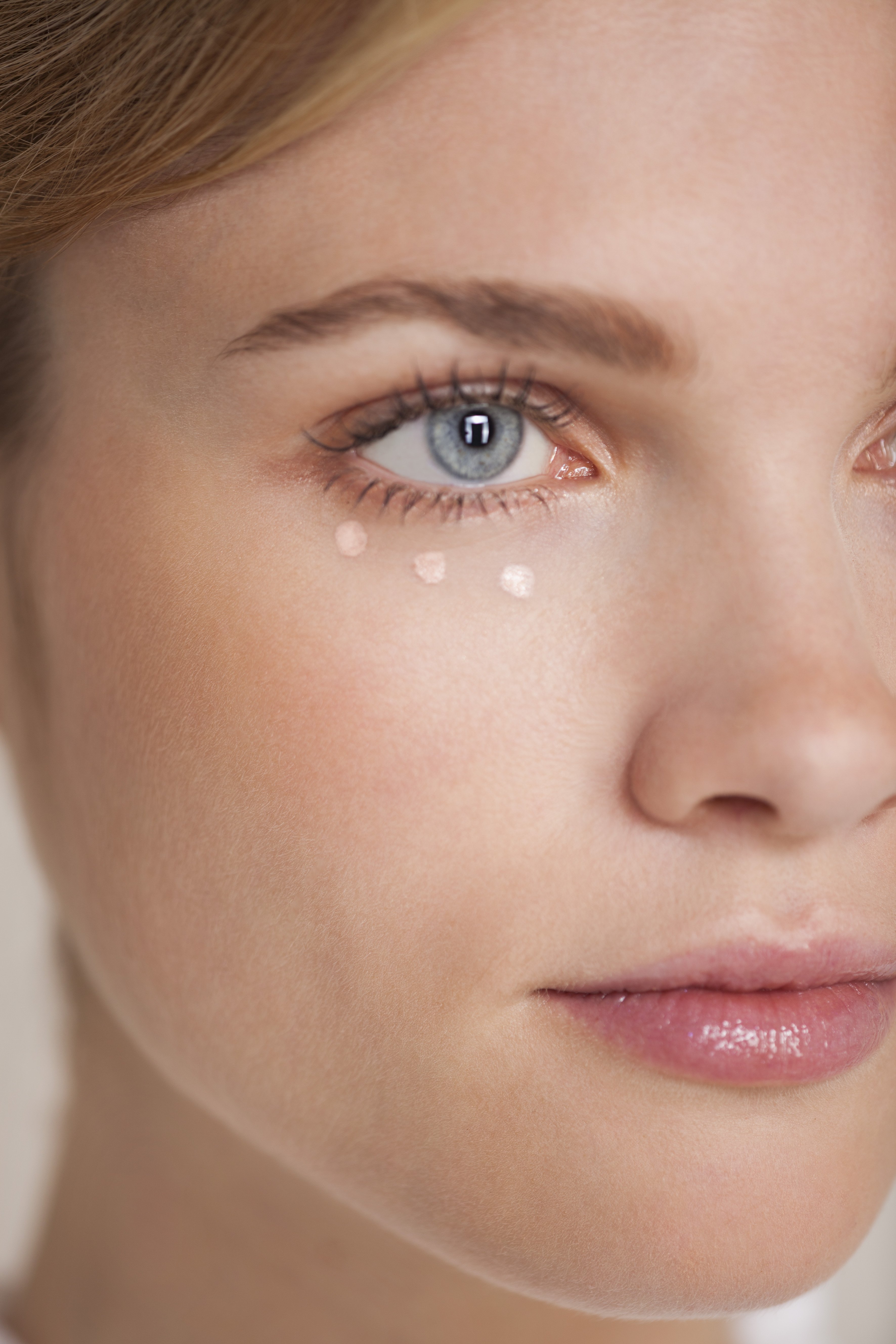 Woman applying concealer. | Source: Getty Images