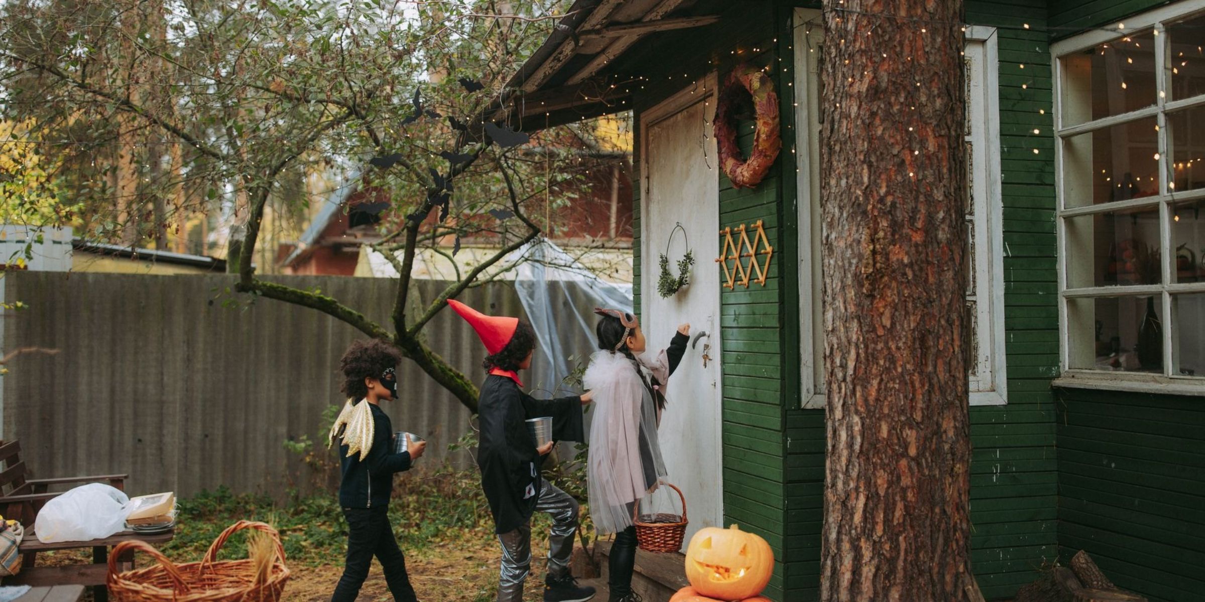 Children dressed in Halloween costumes trick-or-treating at a decorated house | Source: Pexels
