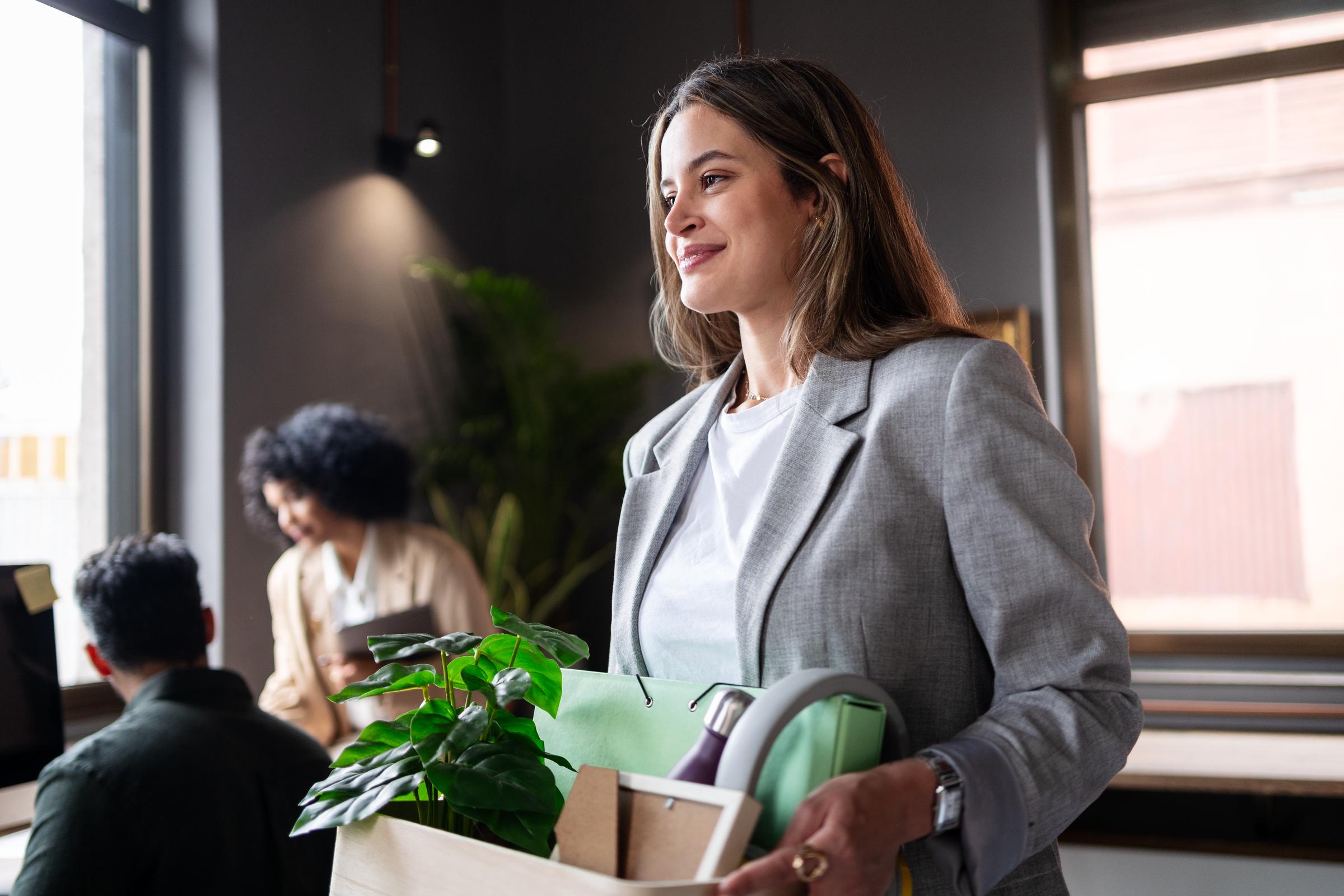 A young woman leaving an office following her resignation | Source: Getty Images