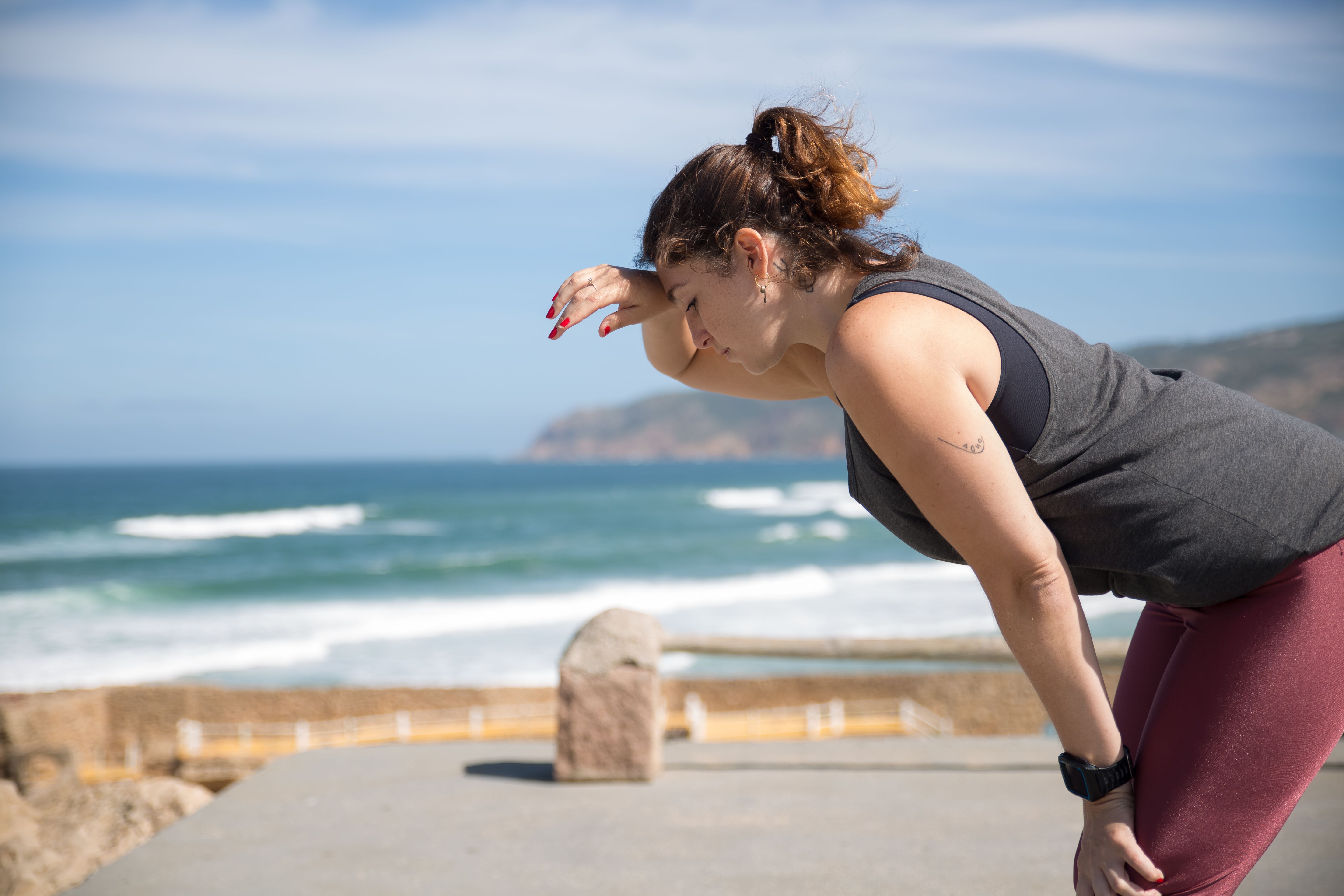 A woman crouching as she takes a break from working out outdoors | Source: Pexels