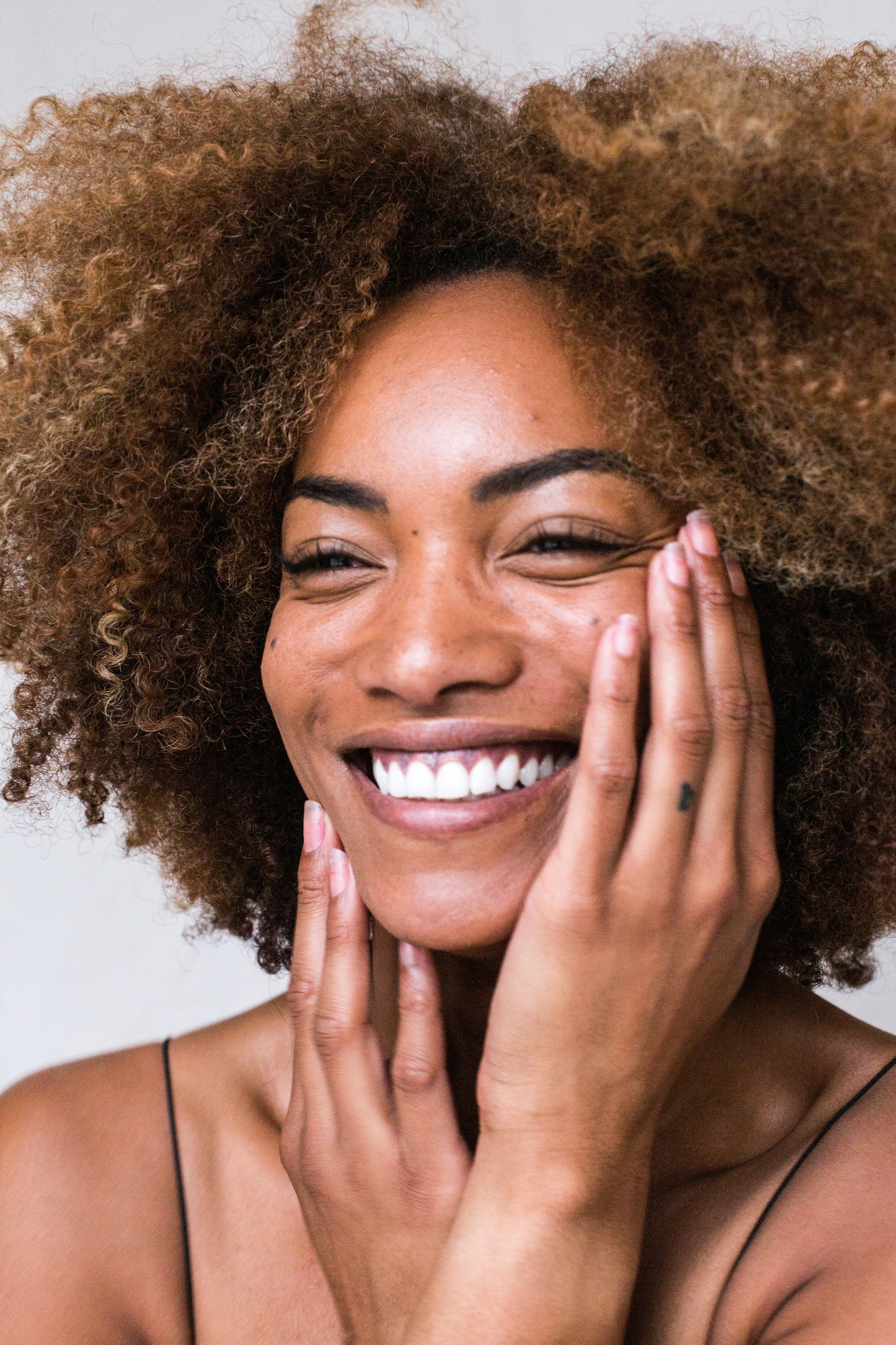 Woman with clear skin and afro | Unsplash 