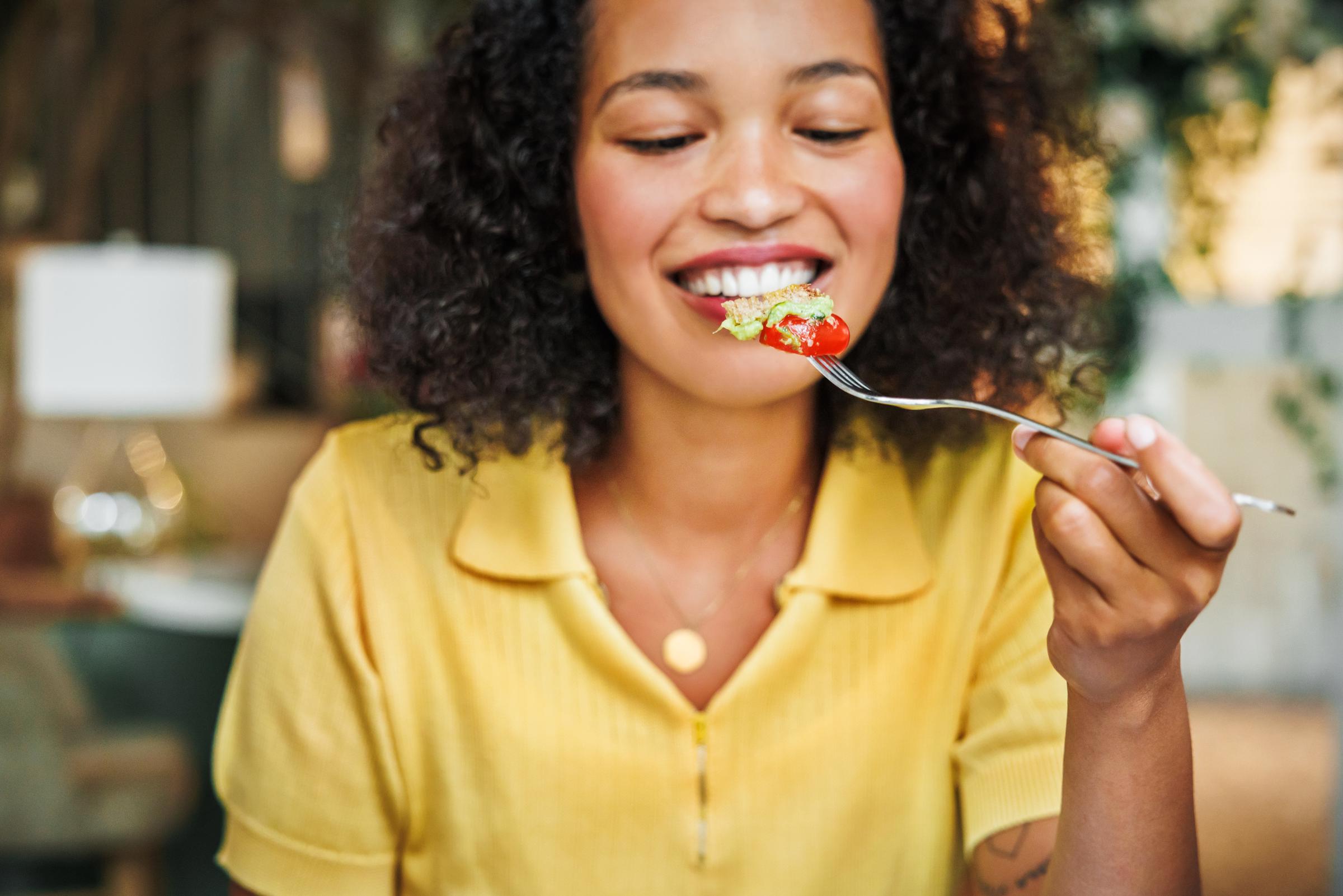A woman about to enjoy a bite of a fresh salad | Source: Getty Images