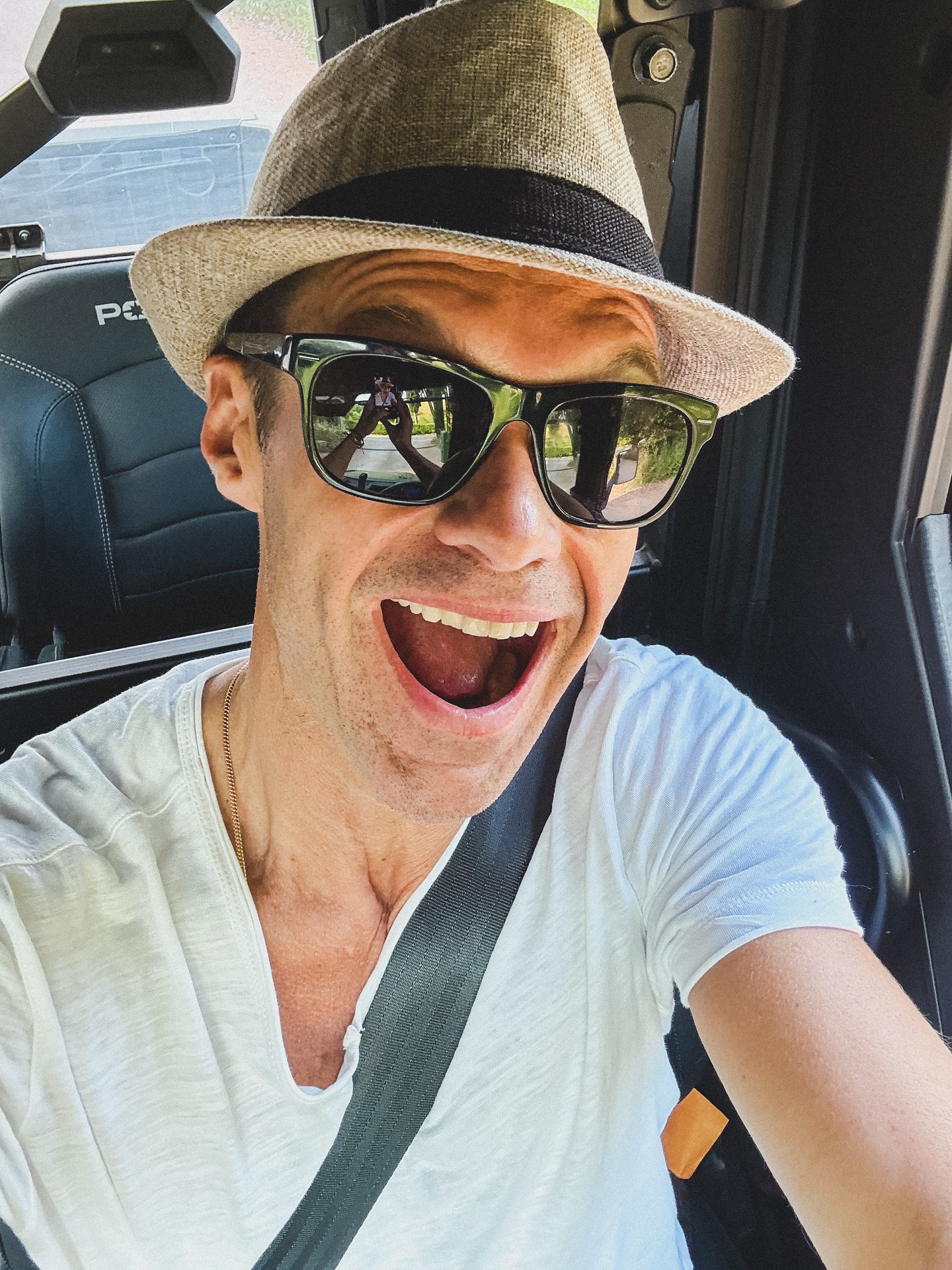 Ryan Seacrest beams behind the wheel, wearing sunglasses and a straw hat, posted on June 30, 2025 | Source: Instagram/ryanseacrest