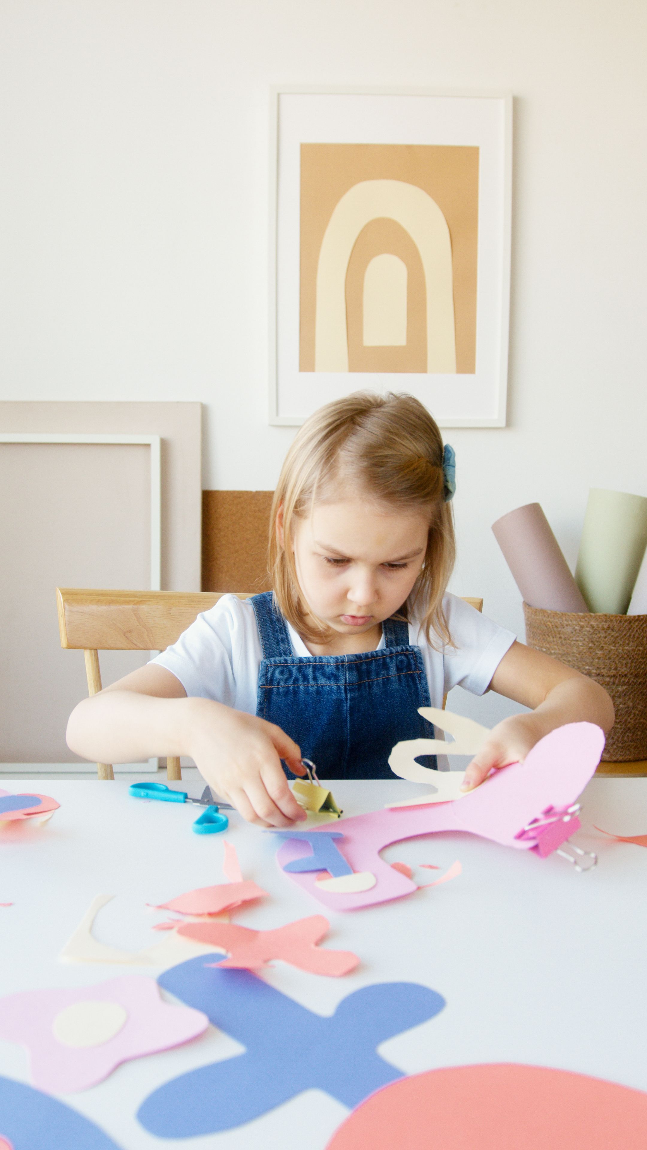 A little girl creating colorful paper shapes | Source: Pexels
