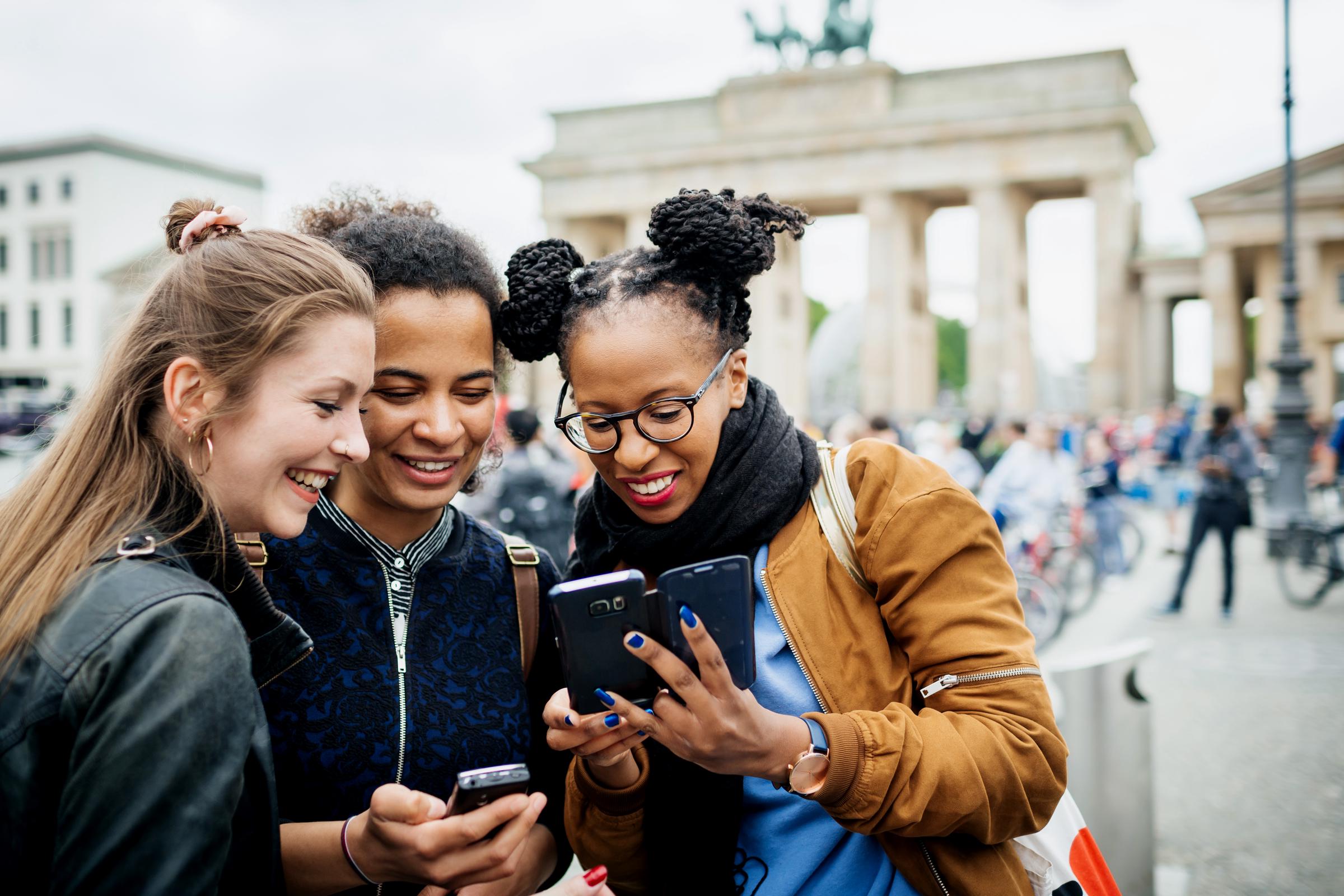 A group of friends traveling together, stopping to take a check something online | Source: Getty Images