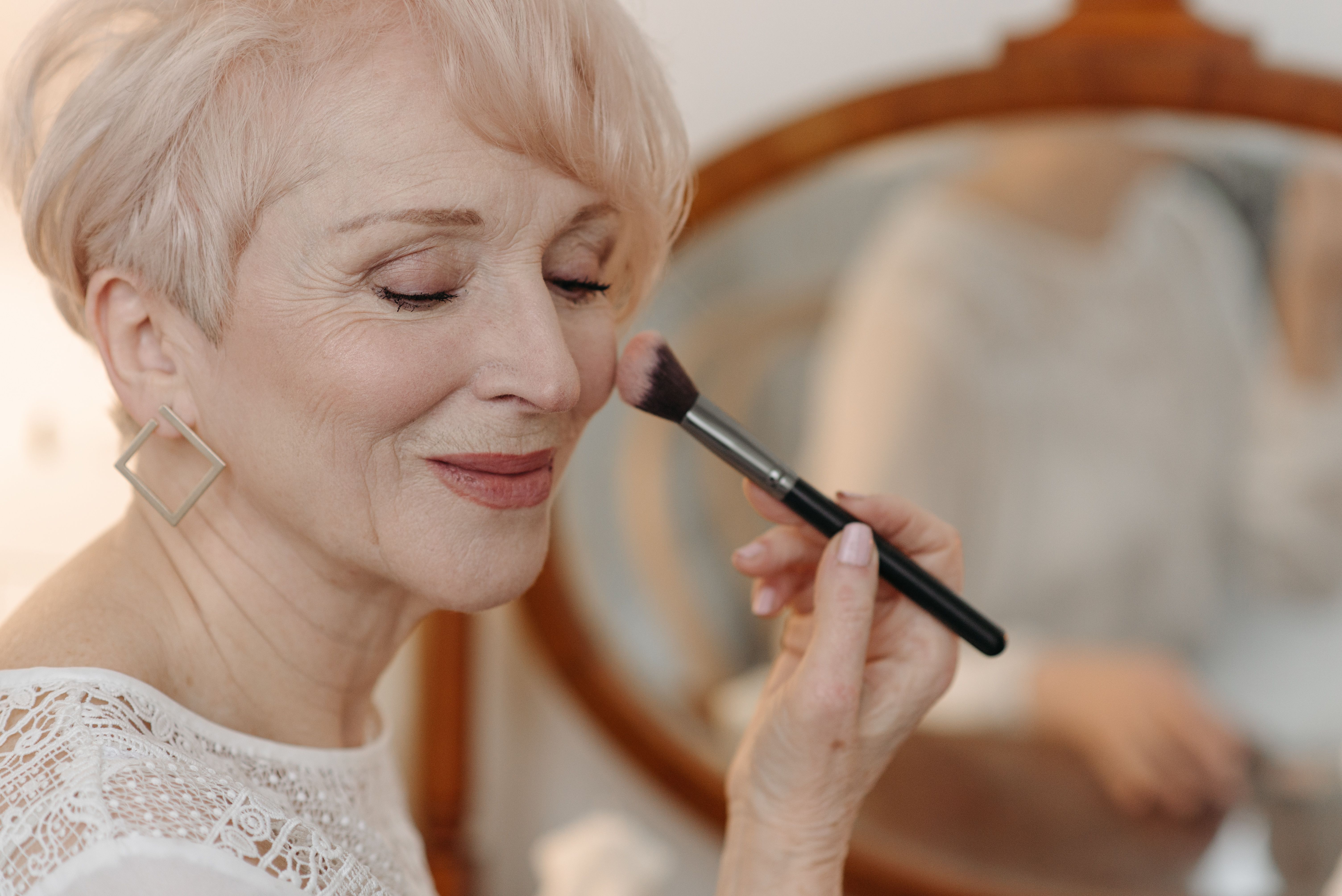 Mature woman applying blush | Source: Pexels