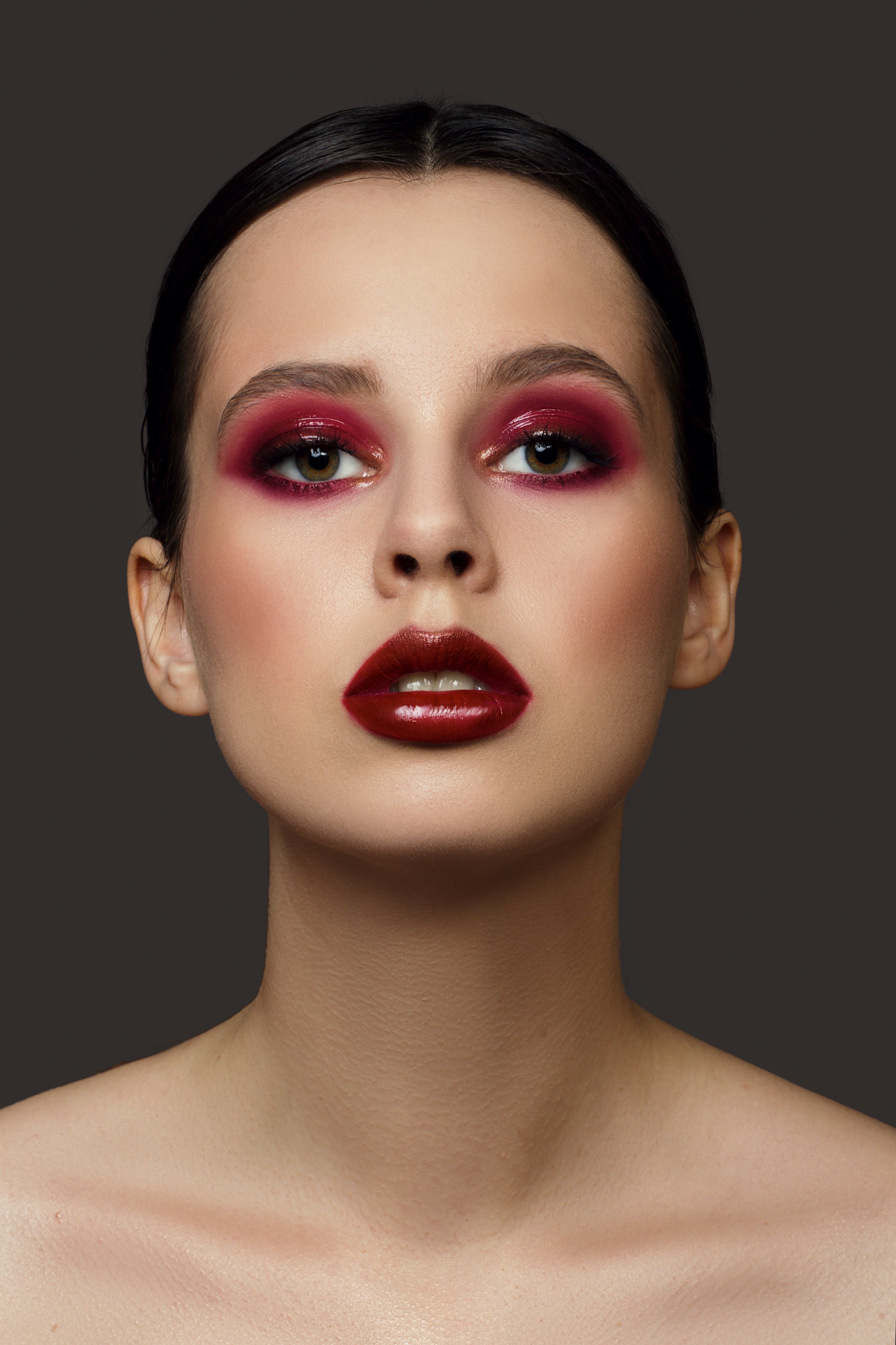 A portrait of a young woman wearing red eyeshadow and lipstick | Source: Shutterstock