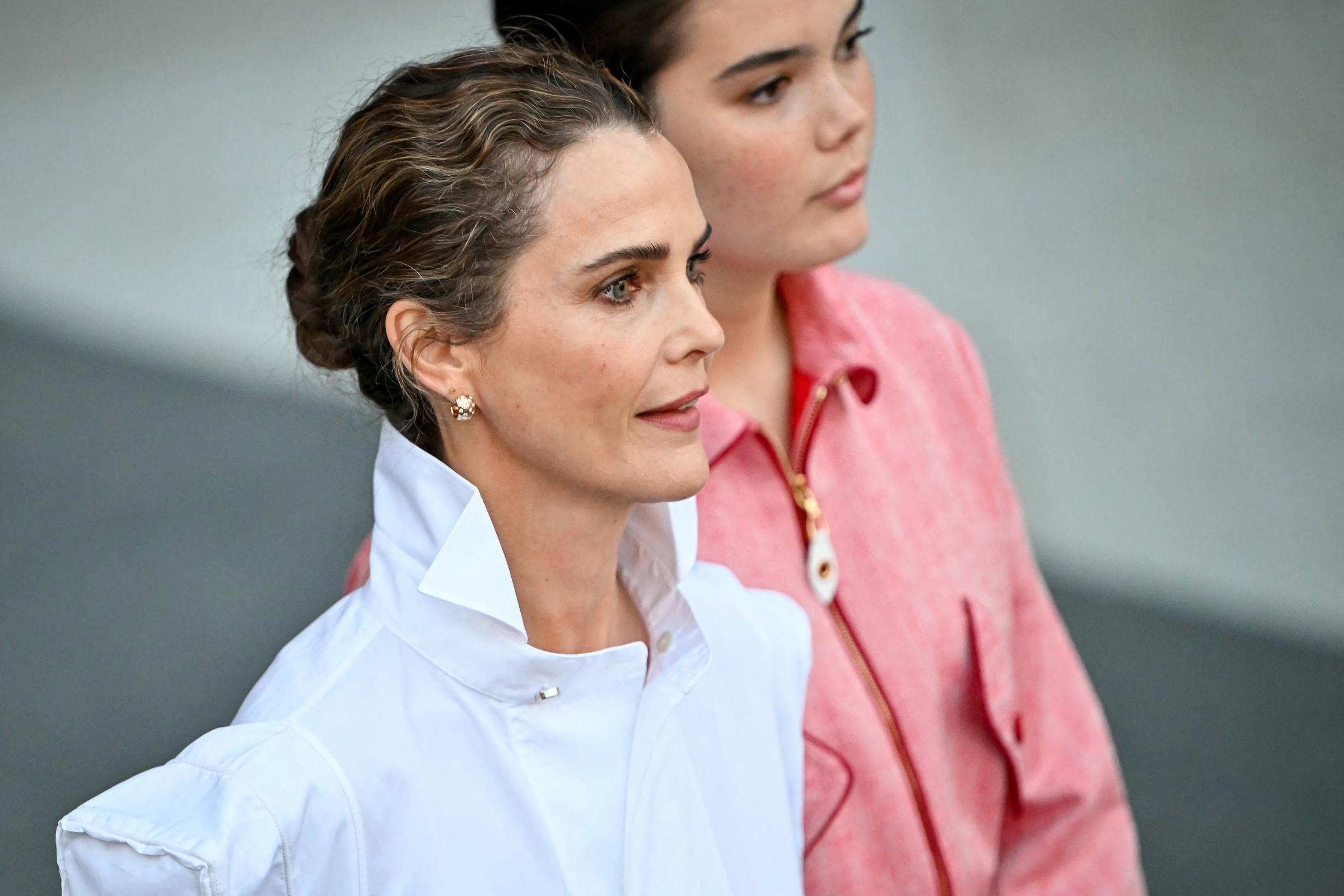 This close-up highlights the contrast in their styling: a sculptural white shirt for the mother and a soft pink jacket for her daughter, giving the pair a polished look without matching outfits. | Source: Getty Images