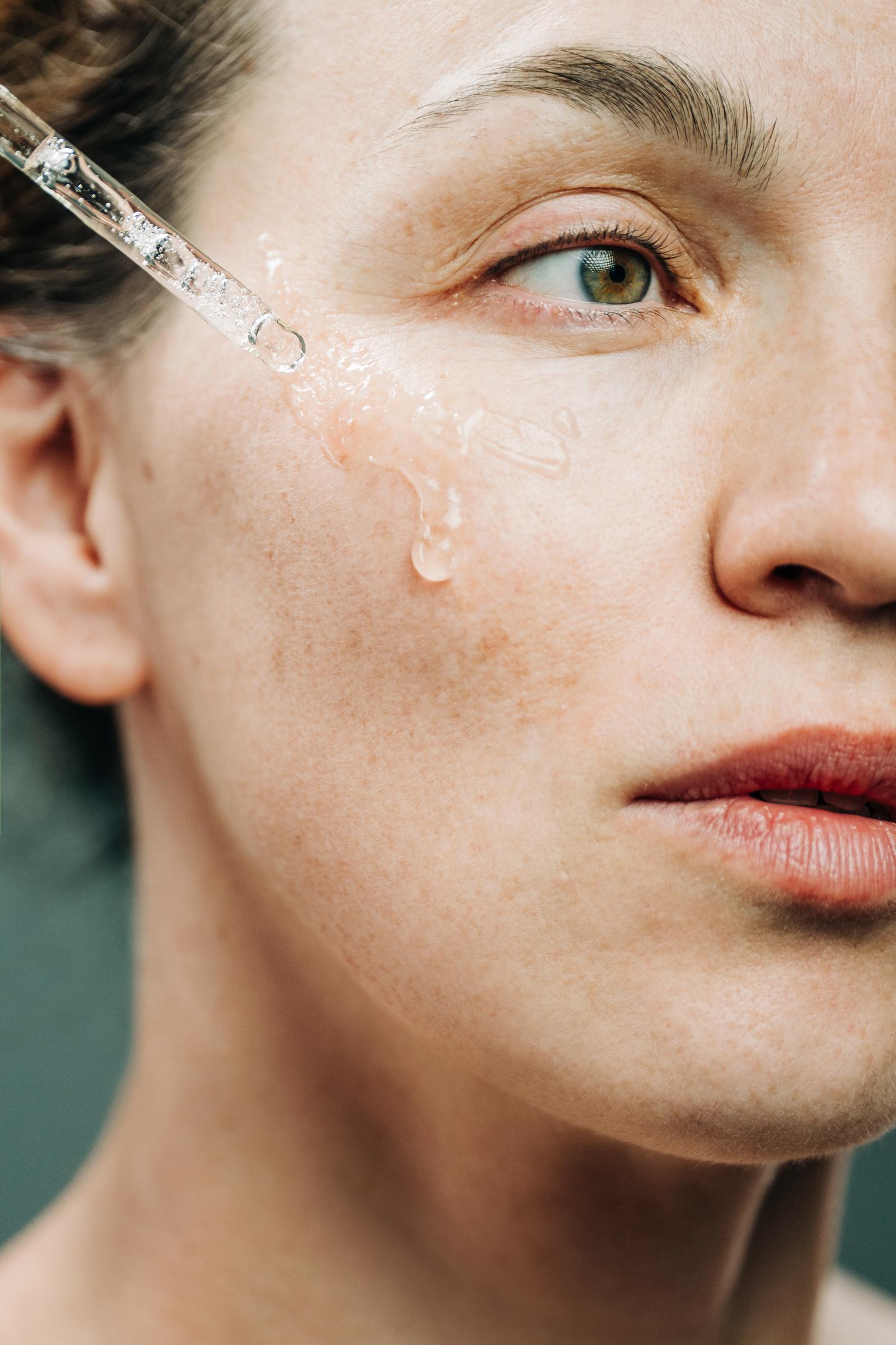 A woman applying serum to her face | Source: Getty Images