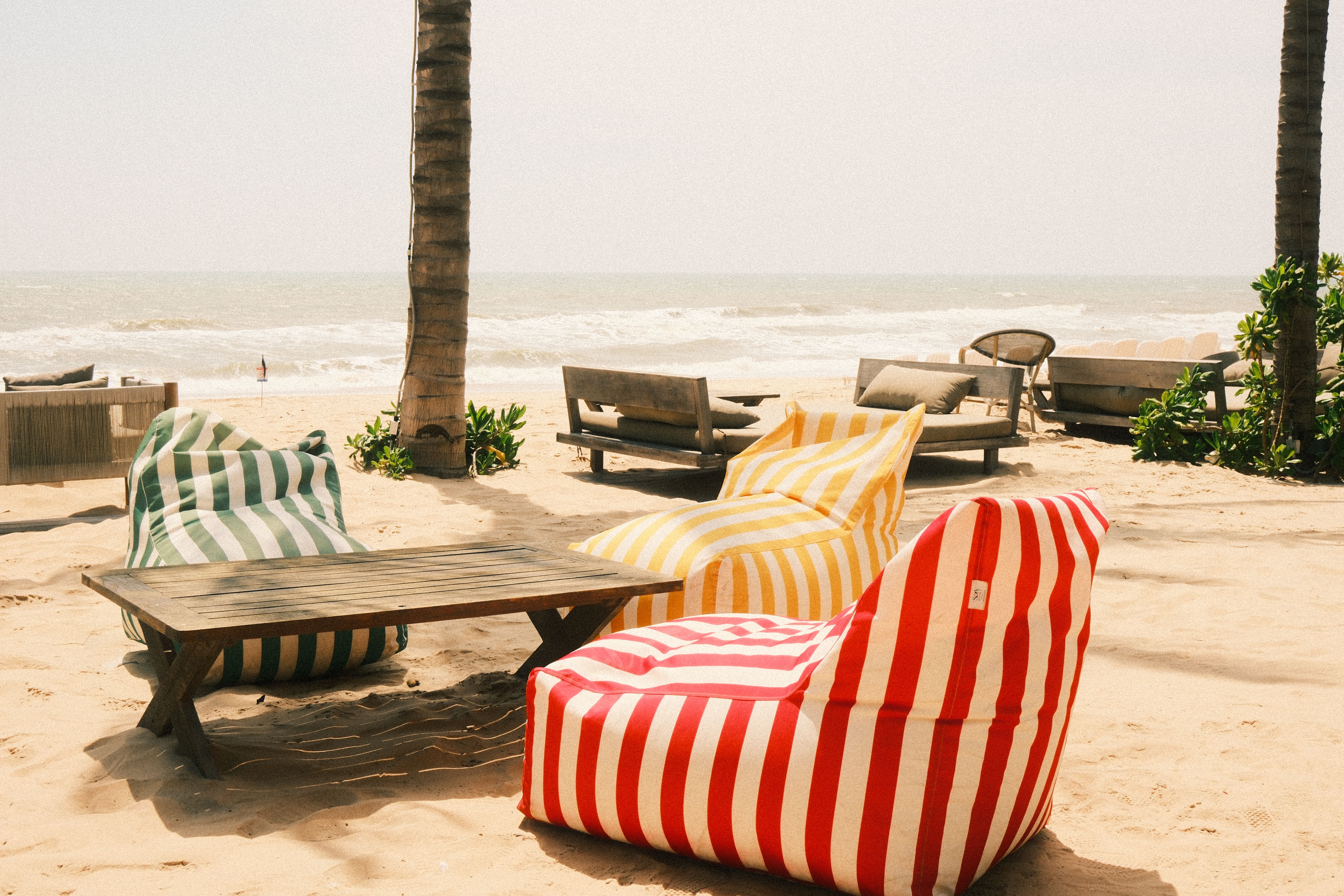 Relax on a sunny beach in with vibrant bean bag chairs by the sea | Source: Pexels