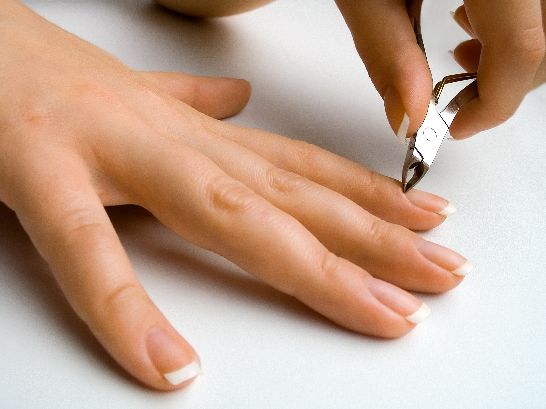 A person removing cuticles from fingernails | Source: Shutterstock