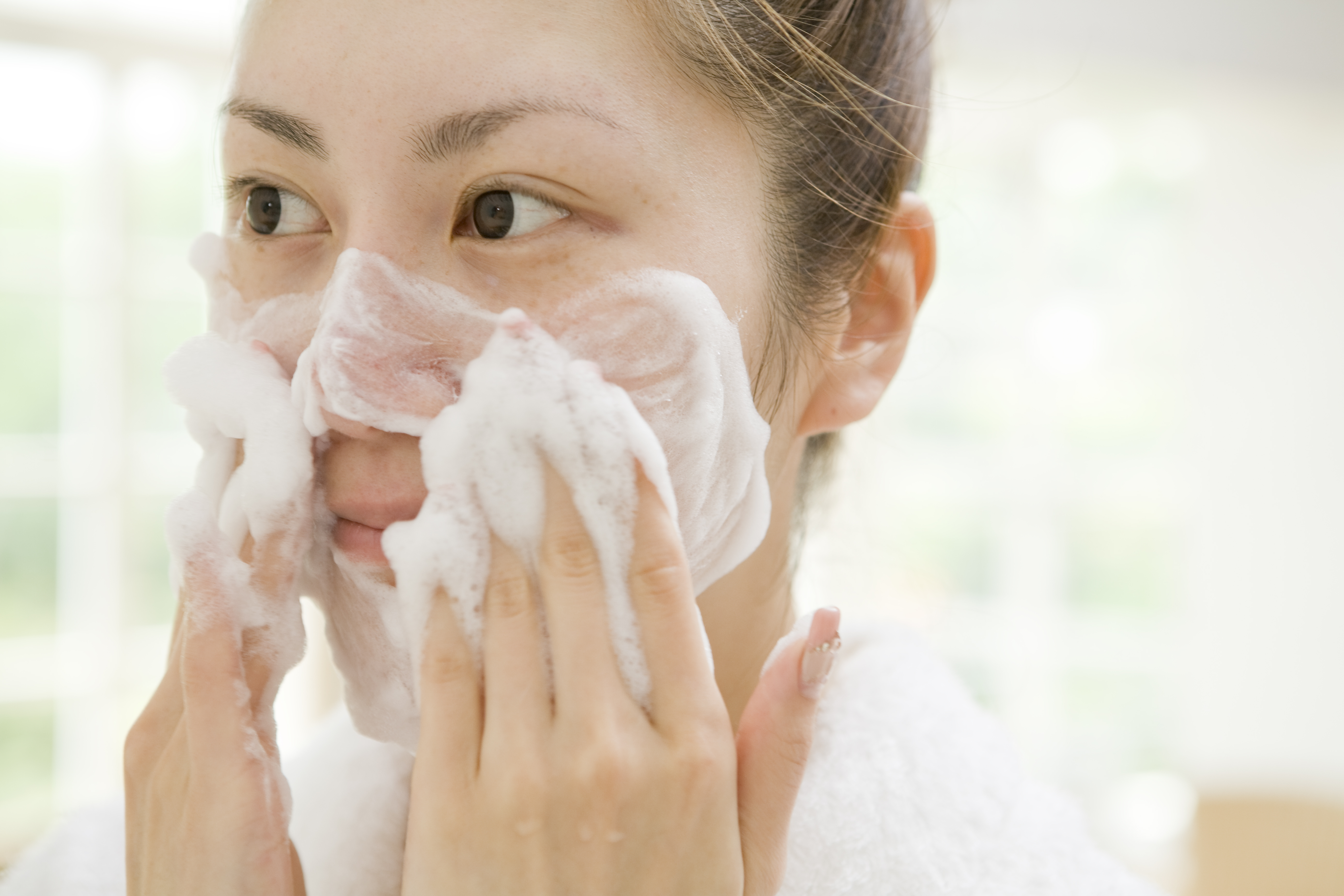 A woman lathering cleanser on her face | Source: Getty Images