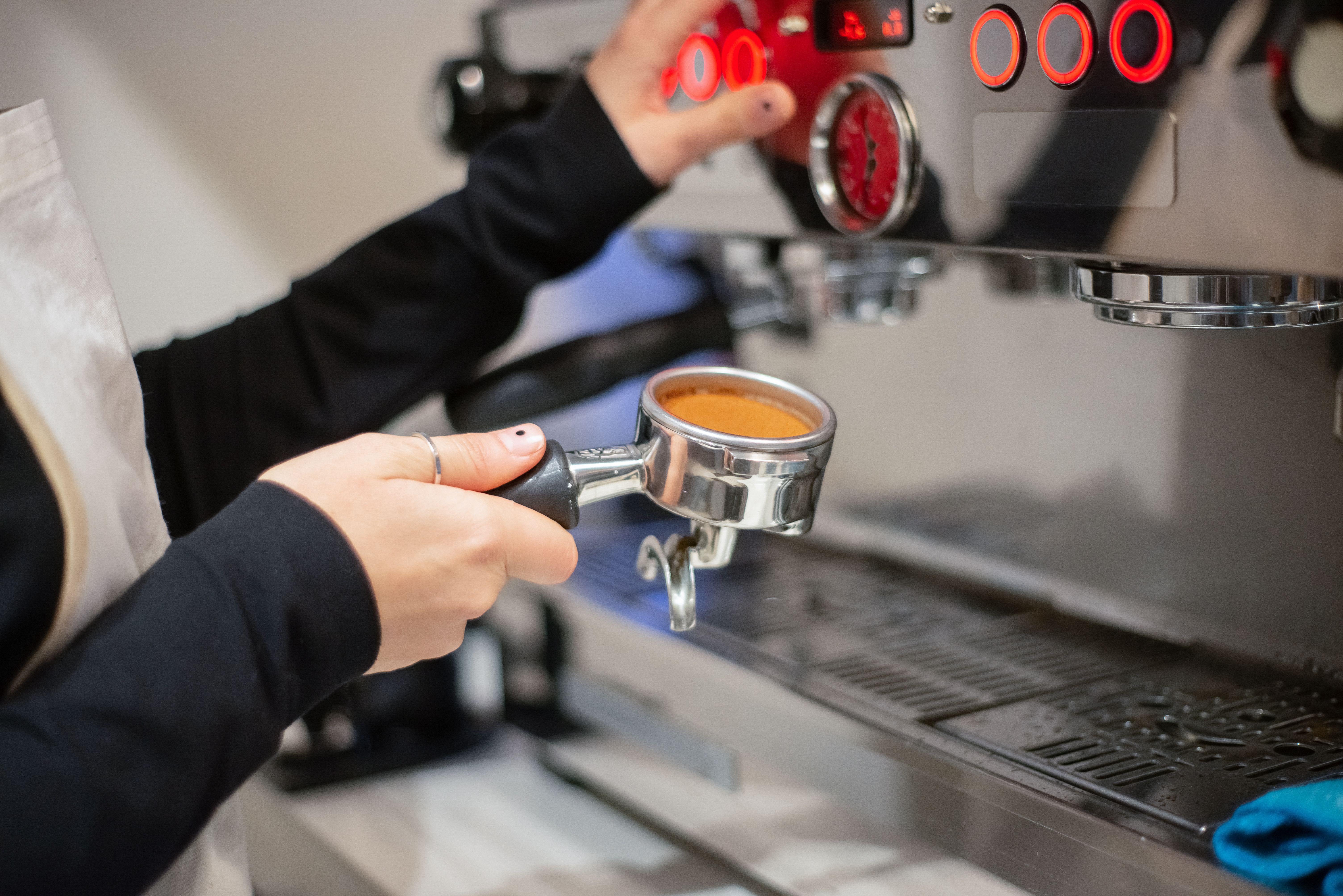 A woman using an espresso machine | Source: Pexels